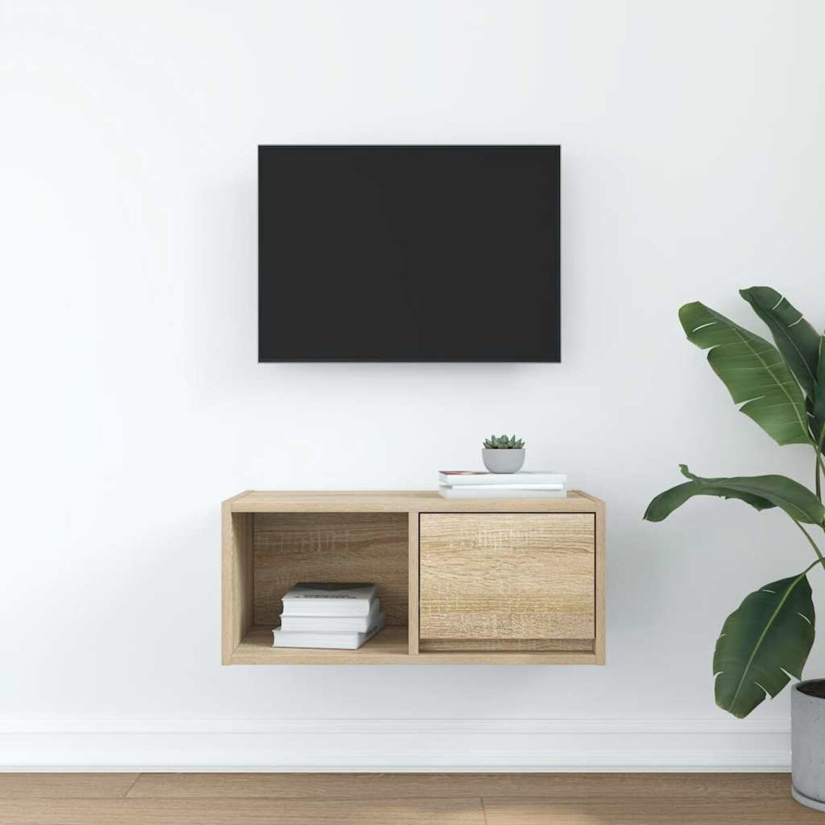 Ein Fernseher über einem Holzschrank mit Büchern und einer Pflanze. Die Wand ist weiß. Der Boden ist aus Holz.