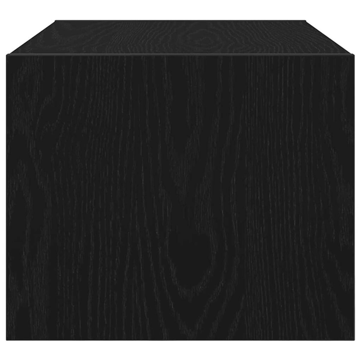 Nahaufnahme eines schwarzen Holzquaders. Die Holzmaserung ist sichtbar. Der Würfel steht auf einer weißen Oberfläche, der Hintergrund ist weiß.