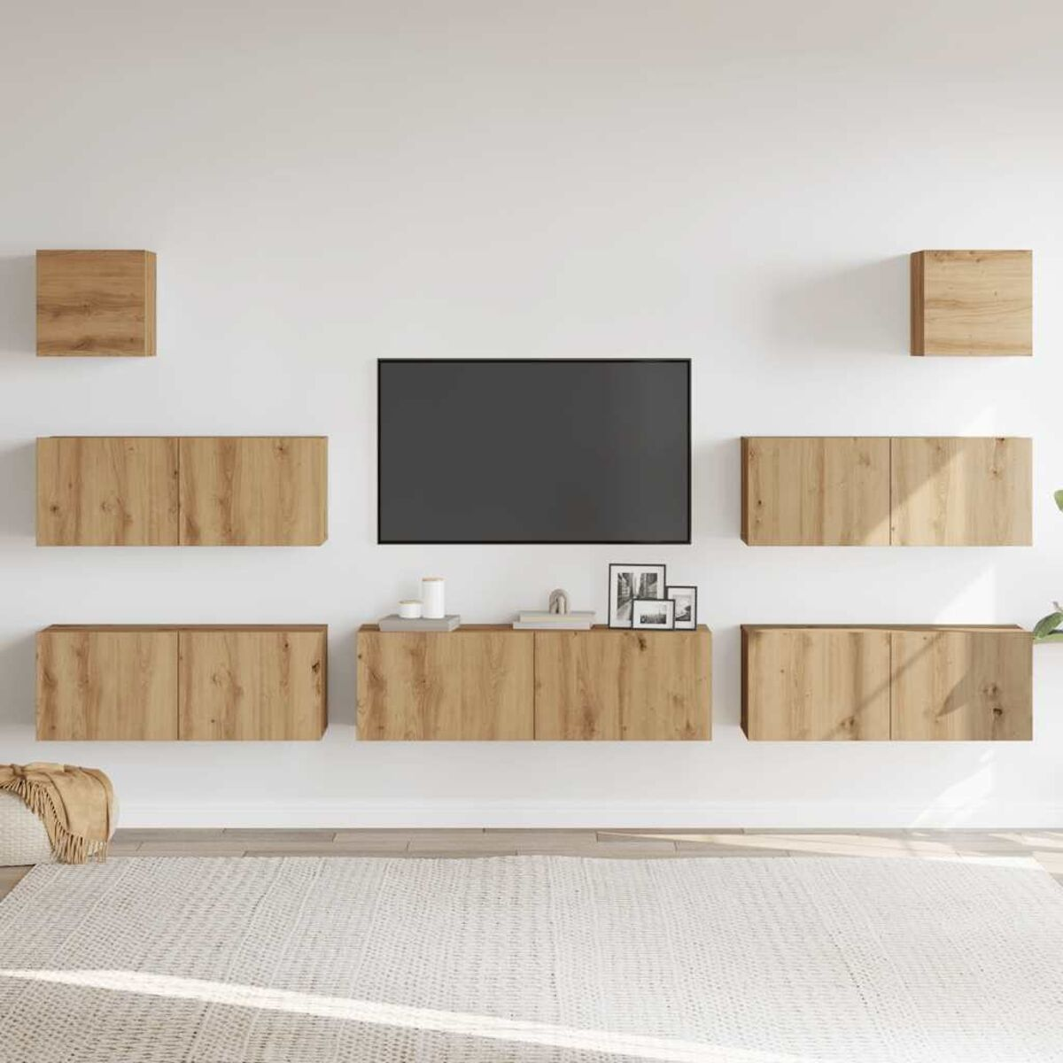 Ein Wohnzimmer mit weißer Wand, Fernseher, Holzschränken und Teppich. Auf den Schränken stehen auch kleine Dekorationsgegenstände.