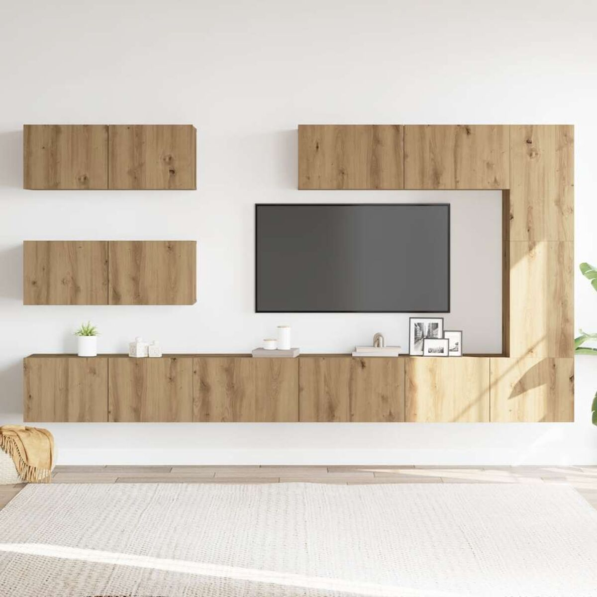 Holzeinheit mit TV, Schränken und Regalen. Weiße Wand und Teppich. Kleine Pflanzen und Dekoration auf Regalen.