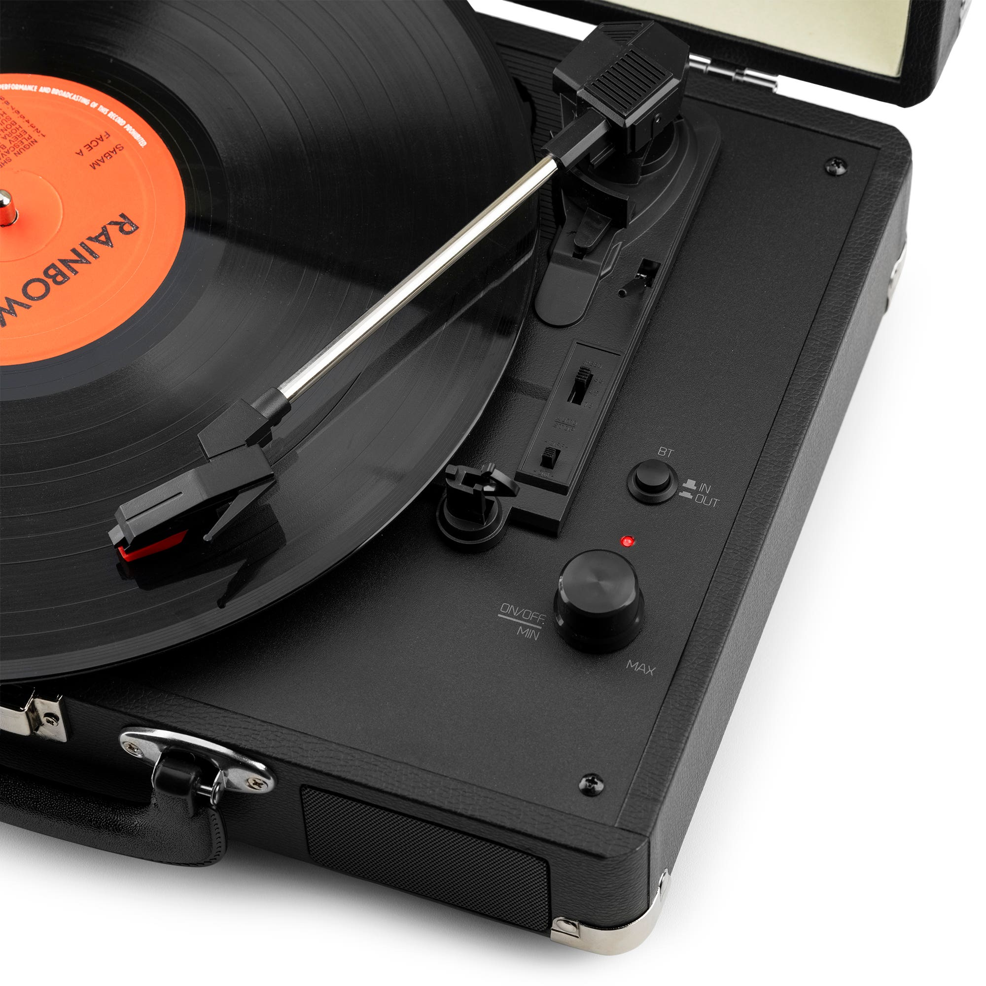 Un tocadiscos negro con un disco de vinilo. La aguja está sobre el disco. El tocadiscos está sobre una superficie blanca.
