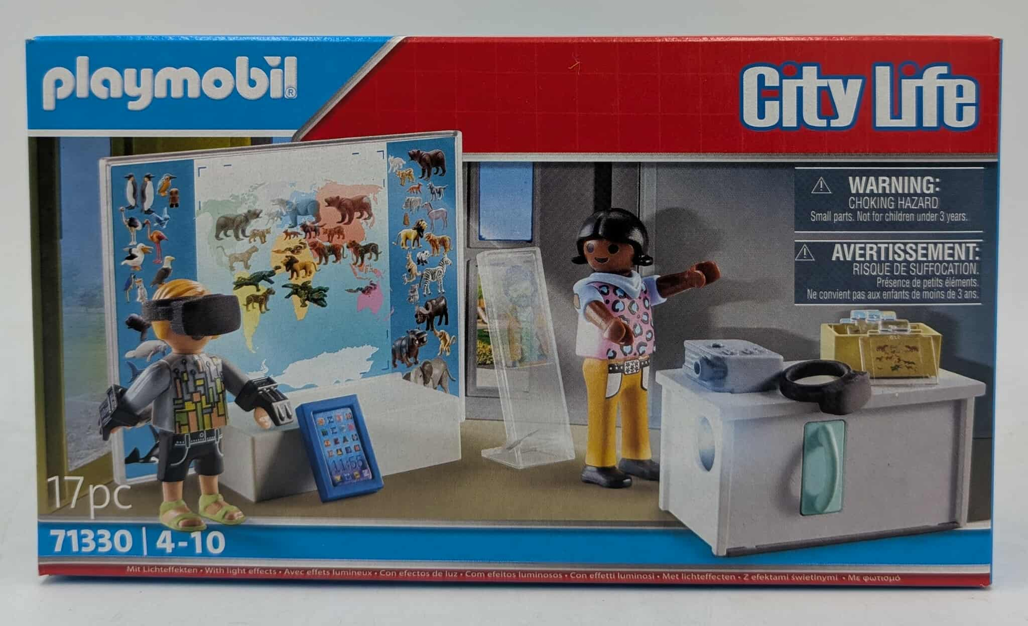 Pudełko Playmobil przedstawia figurkę VR, mapę i postać w różowej koszuli. Zawiera również ostrzeżenia i słowa 'City Life'.