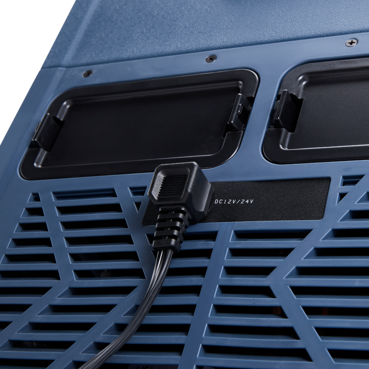 Primo piano di un refrigeratore blu. Un cavo di alimentazione nero è collegato. Due prese d'aria nere sono visibili. Il testo recita DC 12V/24V.