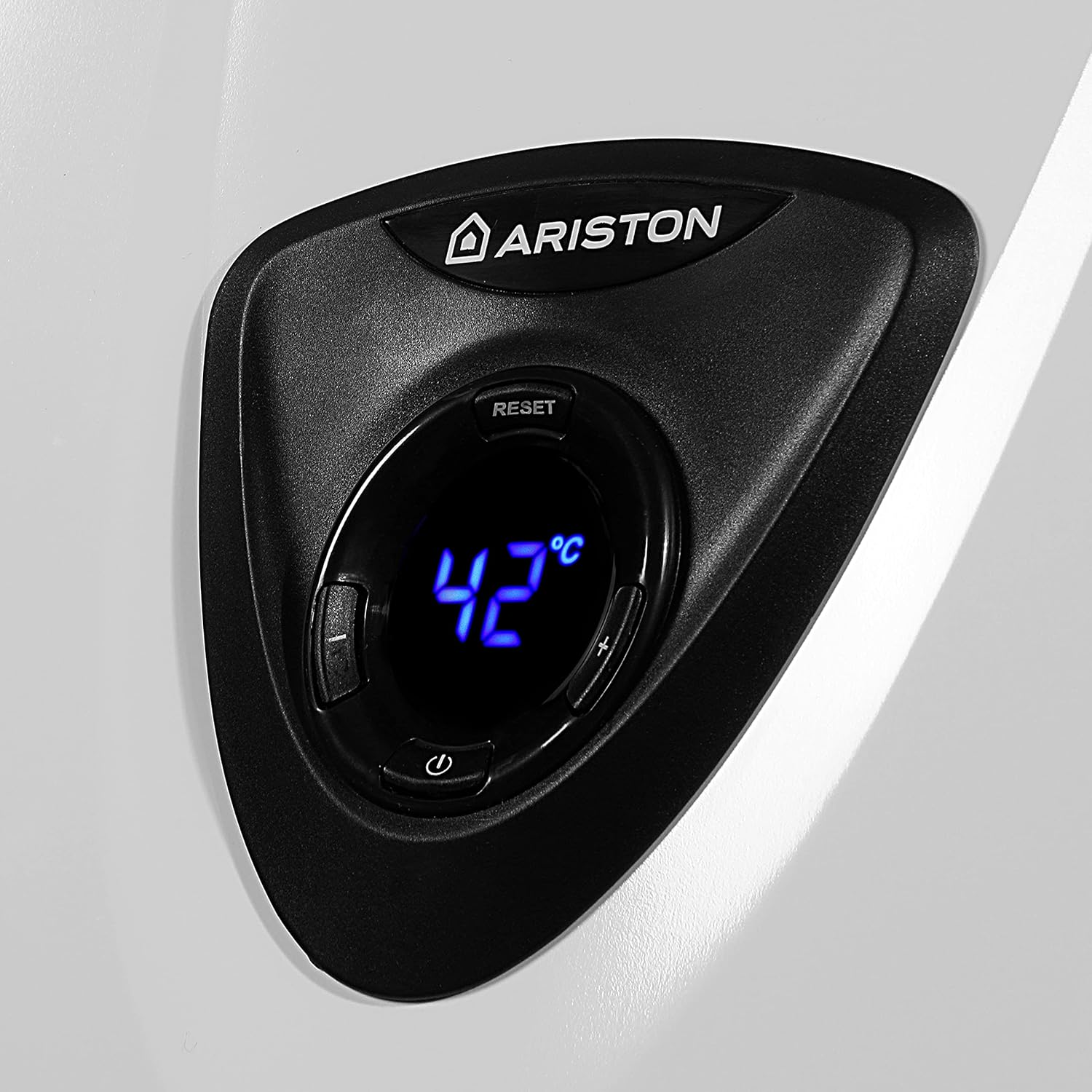 Pannello di controllo nero su superficie bianca. Mostra 'ARISTON' e 42°C. Visibili i pulsanti reset, più, meno e accensione.