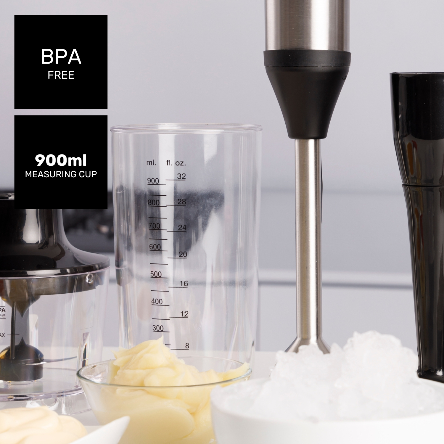 Una batidora de inmersión con una taza medidora, cuencos de comida y una etiqueta sin BPA, con hielo.