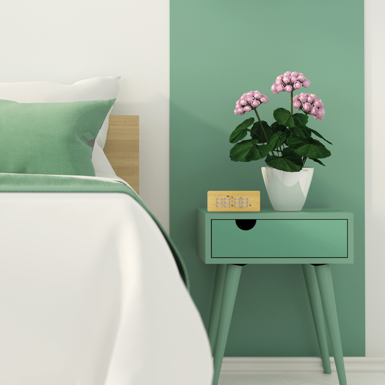 Escena de dormitorio con cama, mesita de noche verde con planta y reloj. La pared tiene una combinación de colores verde y blanco.