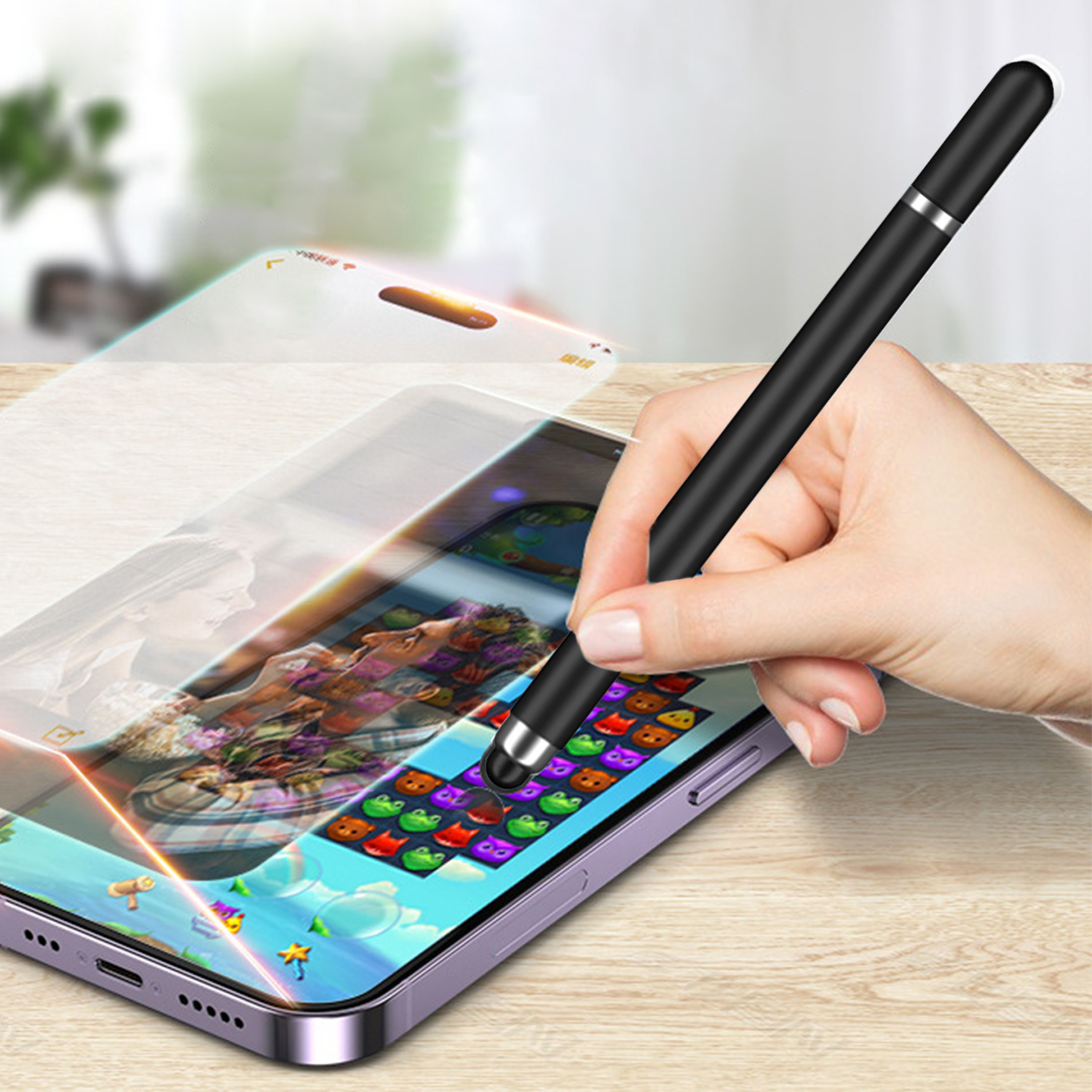 Eine Hand hält einen schwarzen Stift über einem Telefon, auf dem ein Spiel angezeigt wird. Das Telefon liegt auf einer Holzoberfläche.