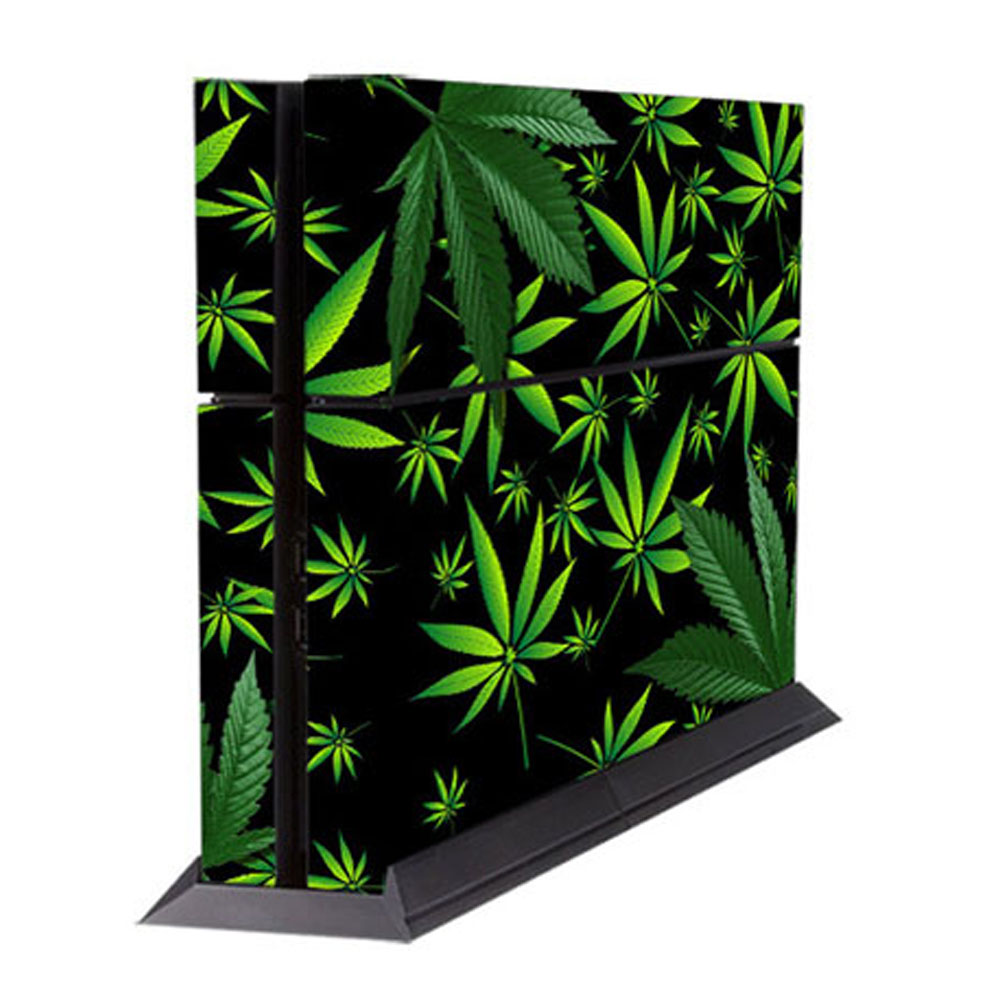 Eine schwarze Spielkonsole mit einem Cannabislatt-Muster. Grüne Blätter auf schwarzem Hintergrund. Die Konsole steht auf einem schwarzen Ständer.
