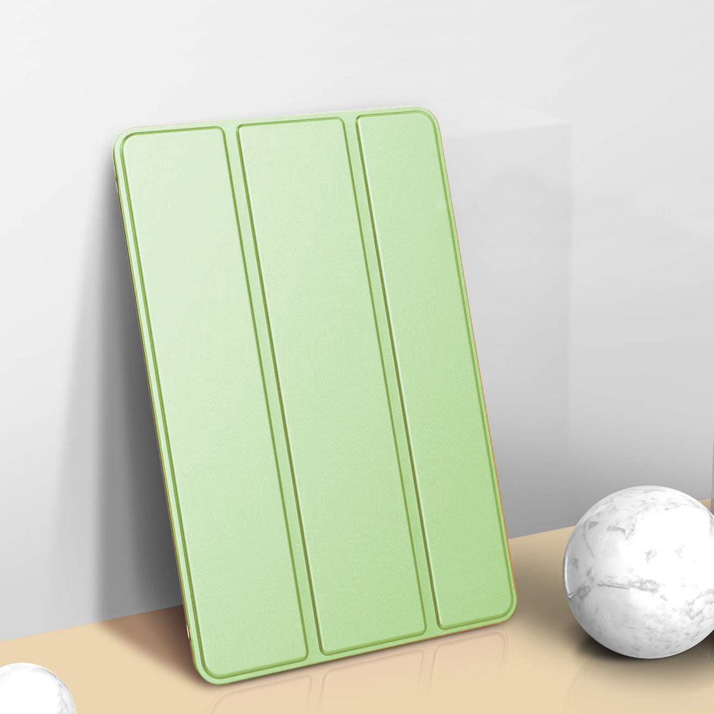 Eine hellgrüne Tablet-Hülle lehnt an einer weißen Wand. Im Hintergrund befindet sich eine Murmelkugel.