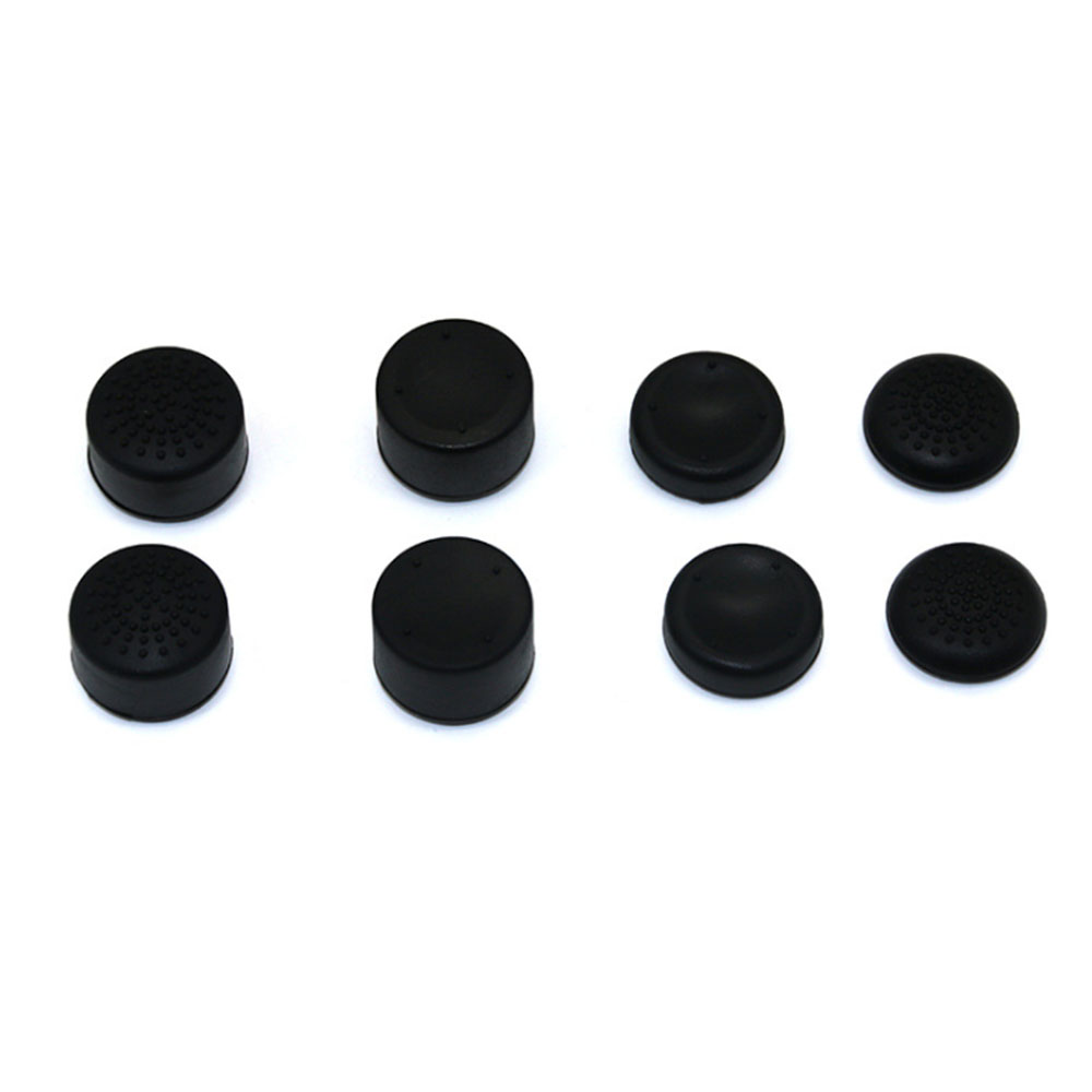 Acht schwarze, kreisförmige Joystick-Daumengriffe sind auf weißem Hintergrund angeordnet. Einige haben strukturierte Oberflächen, andere sind glatt.