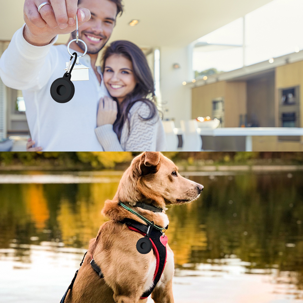 Ein Paar hält Schlüssel mit einem Schlüsselanhänger, im Vordergrund ein Hund mit einem ähnlichen Anhänger. Im Hintergrund ein See und Blätter.