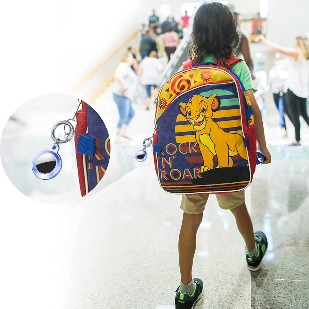 Ein Kind mit einem Lion-King-Rucksack geht in einem Schulflur. Ein AirTag ist am Rucksack befestigt. Andere Leute sind im Hintergrund.