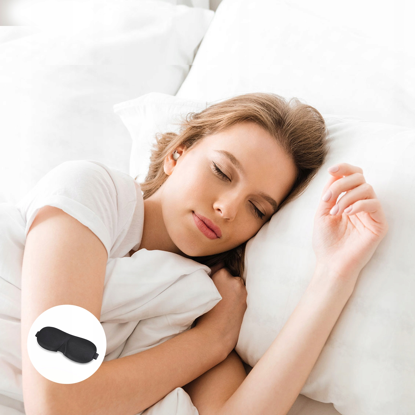 Kobieta śpi na białej poduszce, nosząc maskę do spania. Jej oczy są zamknięte. Czarna maska do spania jest w rogu.
