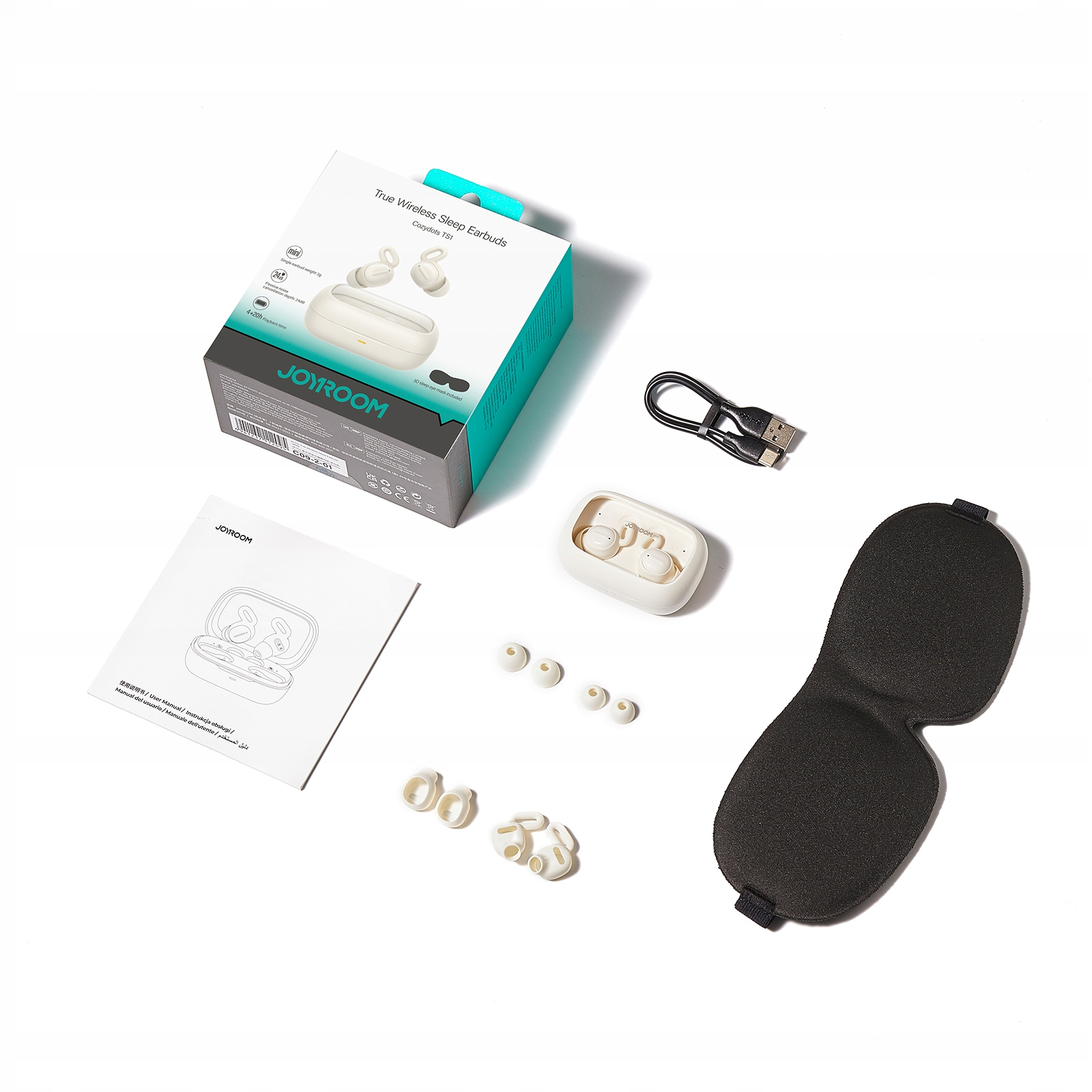 Białe pudełko, słuchawki, końcówki douszne, kabel ładujący, maska do spania i instrukcja na białej powierzchni.