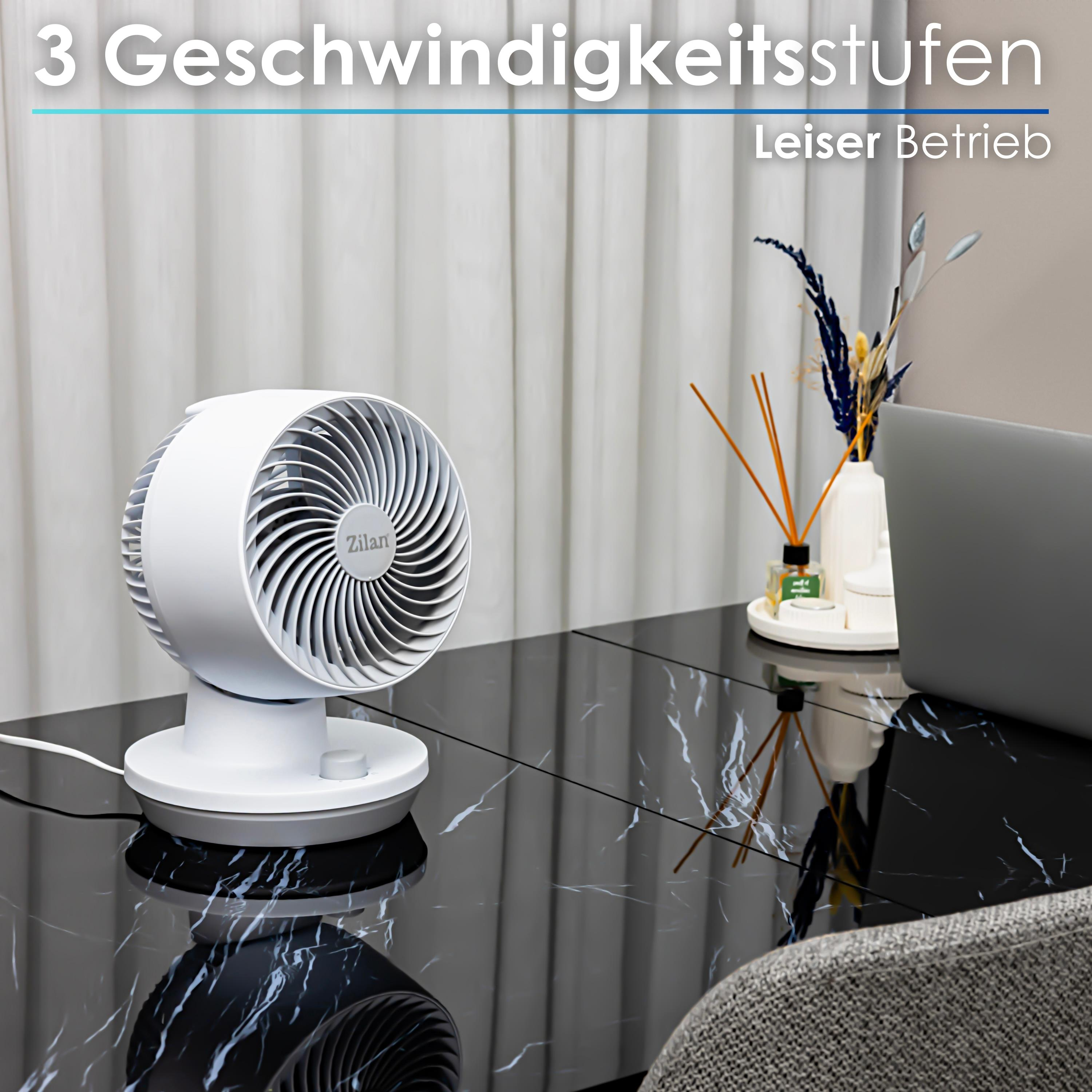 Weißer Ventilator auf schwarzem Marmortisch. Hintergrundvorhänge, Laptop und Dekoration.