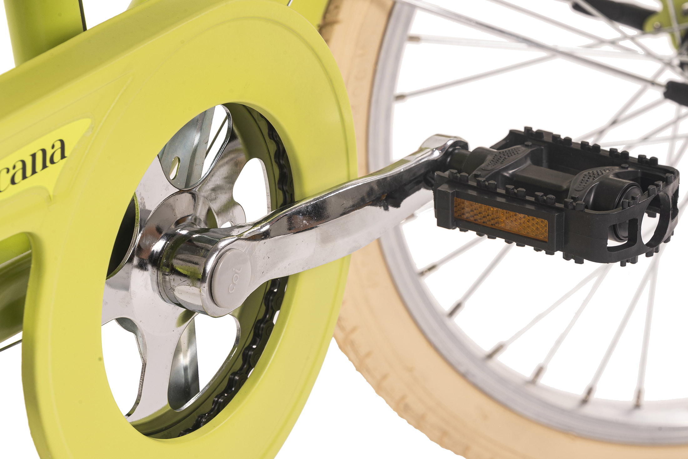 Nahaufnahme von Fahrradpedal, Kettenblatt und Rad. Das Pedal ist schwarz, das Kettenblatt silber und gelb, und das Rad beige.