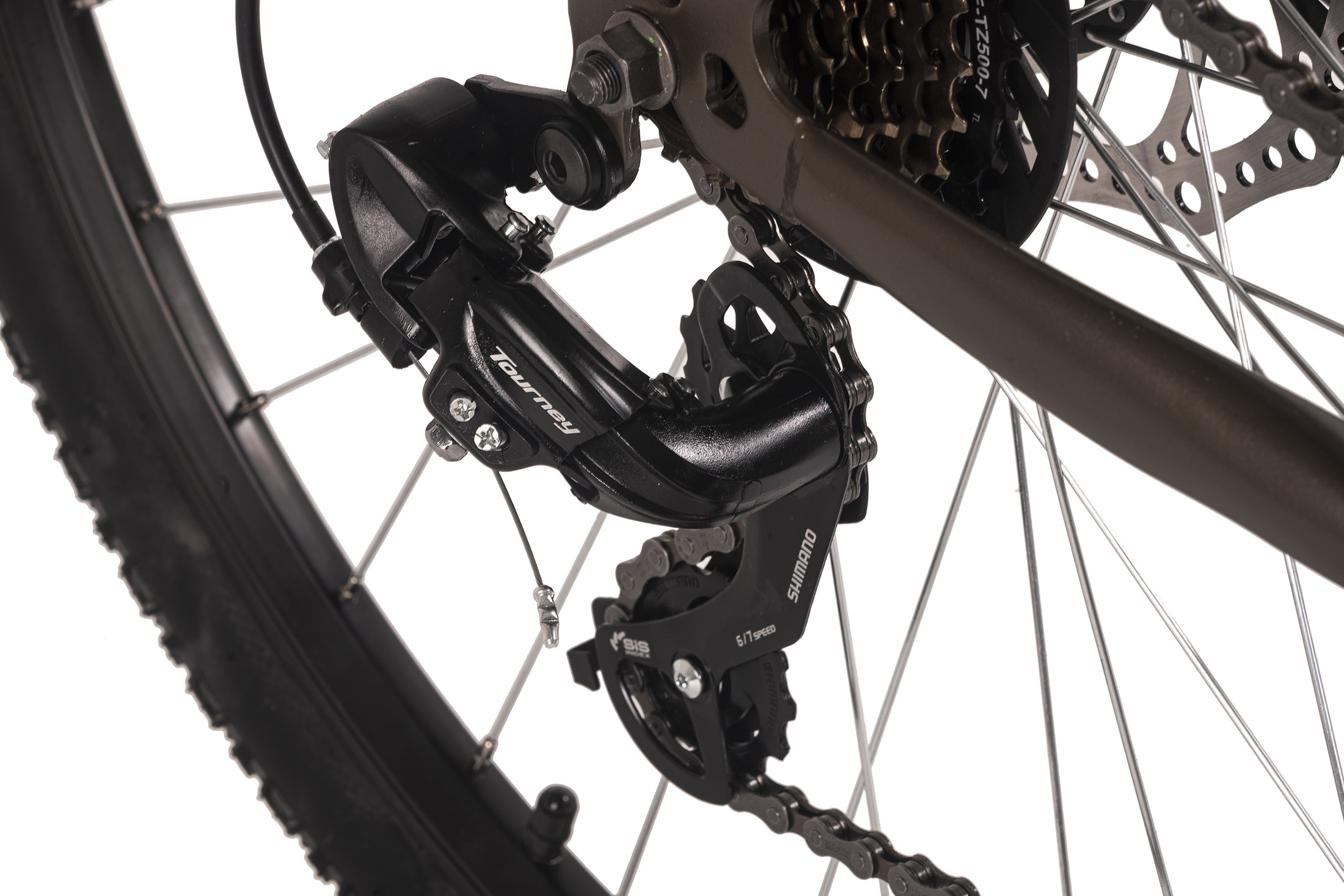Nahaufnahme von Fahrradschaltwerk, Kette und Ritzeln. Das schwarze Schaltwerk ist mit 'Tourney' und 'Shimano' beschriftet. Die Kette ist verbunden.
