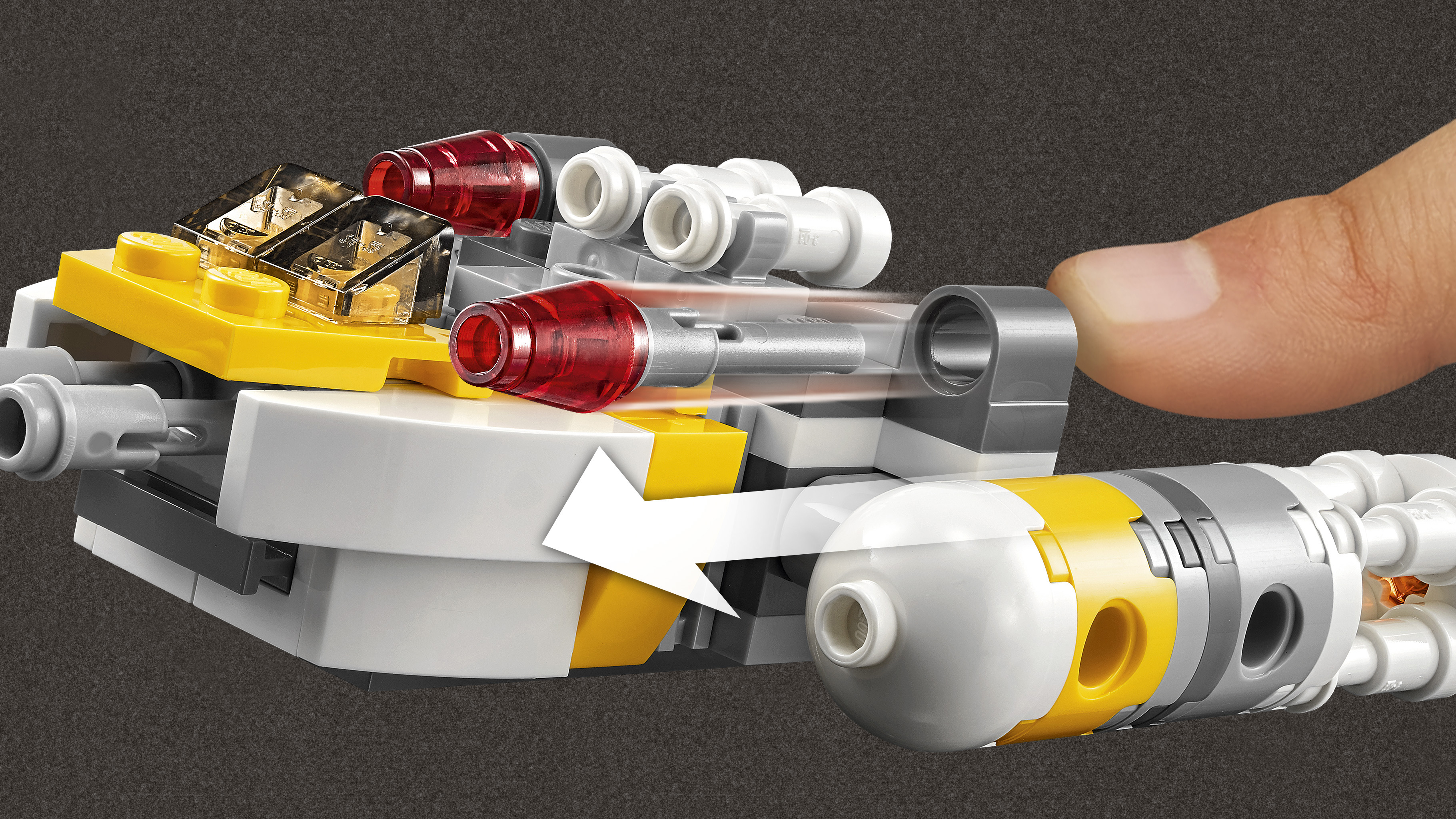 Un modello Lego con parti gialle, grigie e bianche e luci rosse. Un dito tocca il modello, suggerendo un movimento indicato da una freccia.
