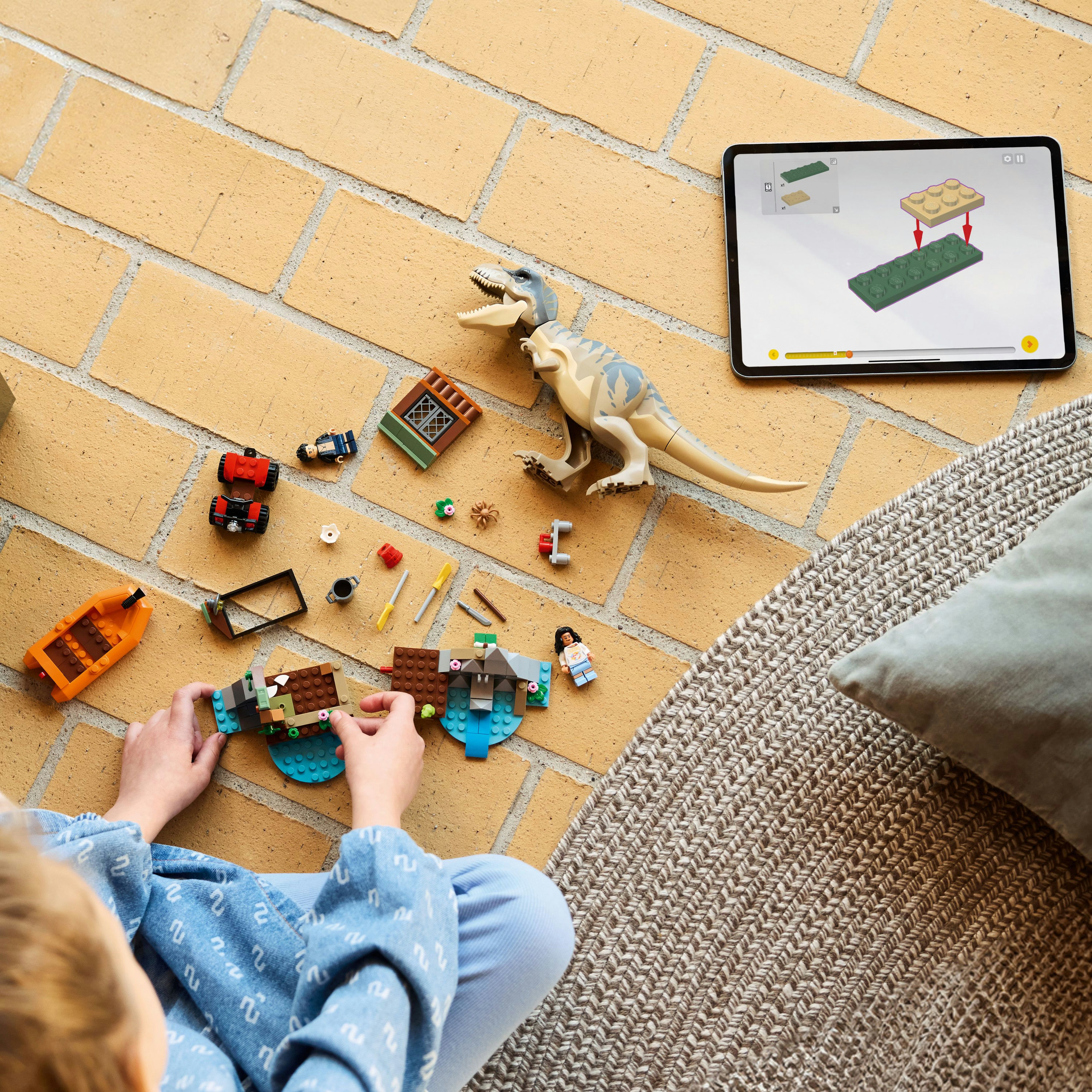 Un niño ensambla un juego de Lego. Una tableta muestra instrucciones. Un dinosaurio de juguete y otras piezas de Lego están en la escena.