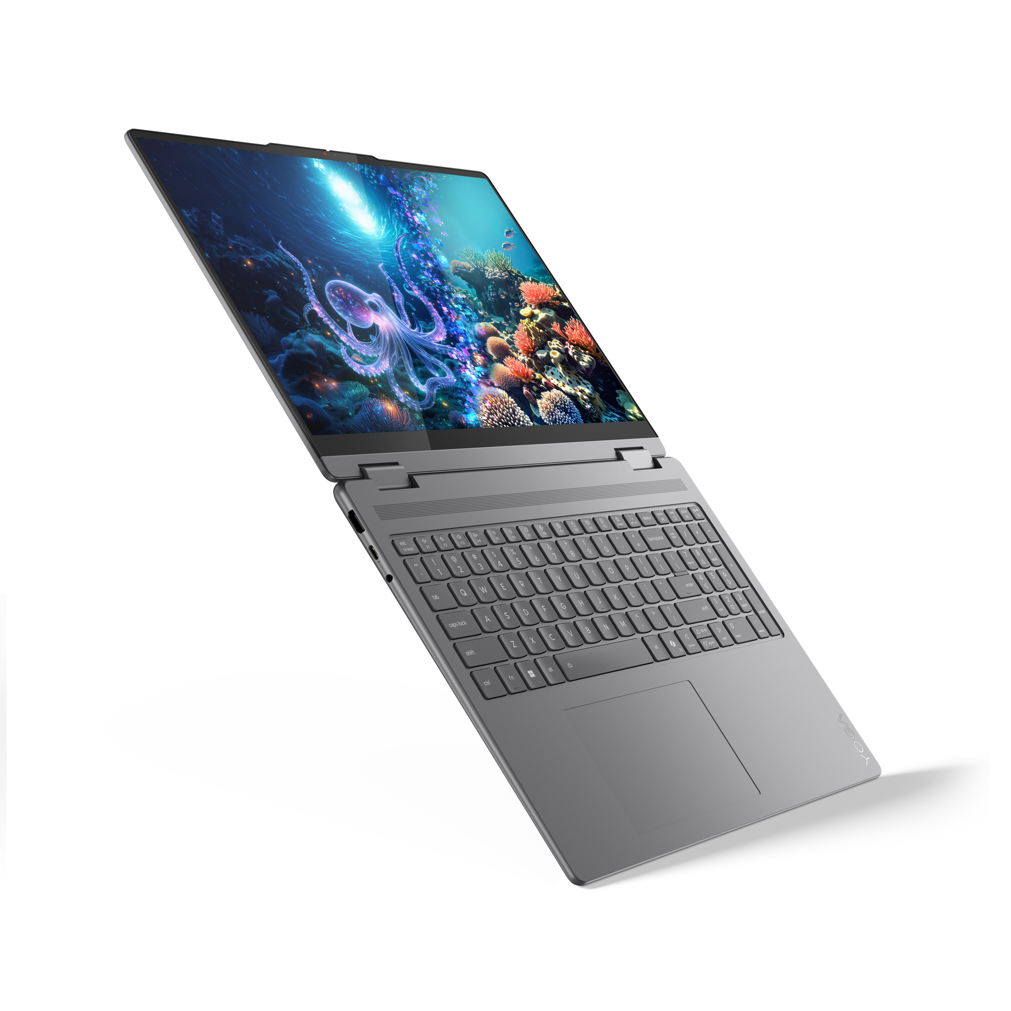 Szary laptop jest otwarty, wyświetlając podwodną scenę z ośmiornicą. Klawiatura jest widoczna, a tło białe.