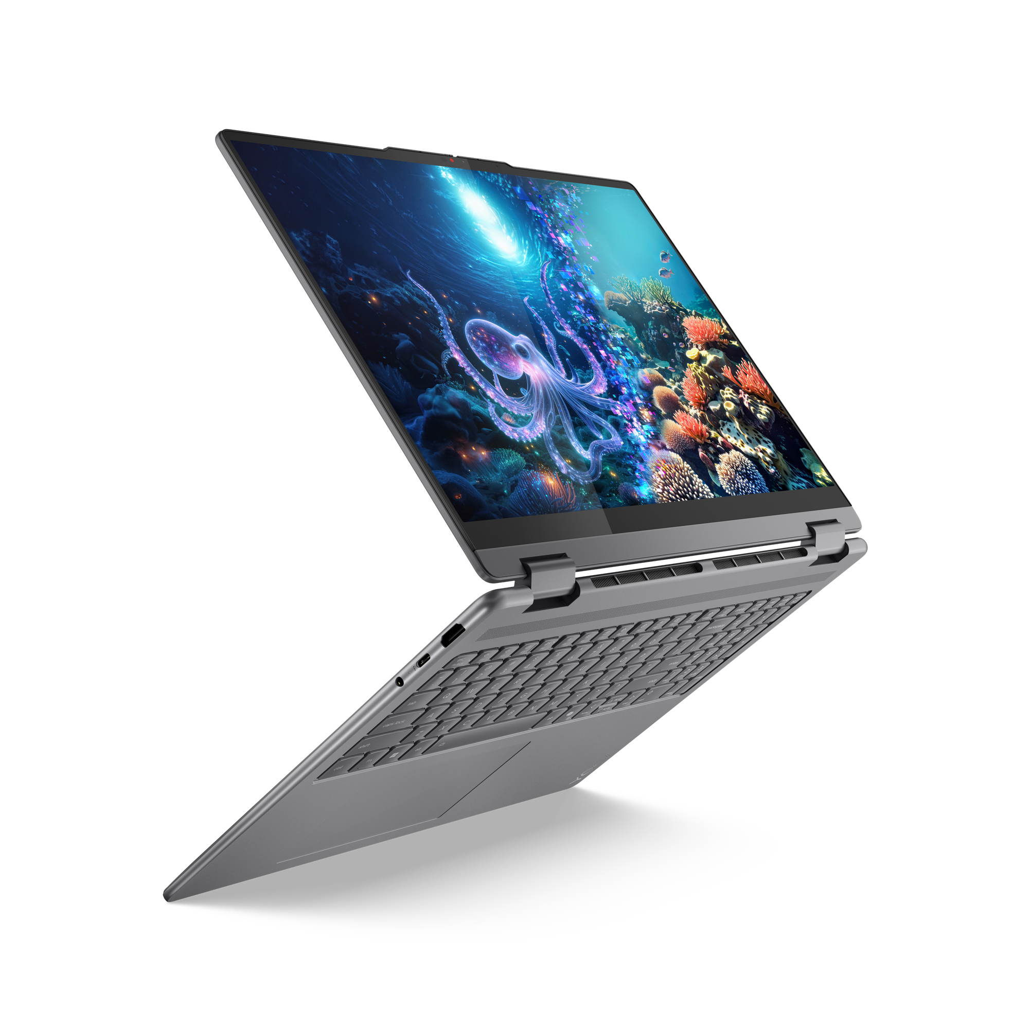 Szary laptop jest otwarty, wyświetlając podwodną scenę z ośmiornicą. Klawiatura jest widoczna, a tło białe.
