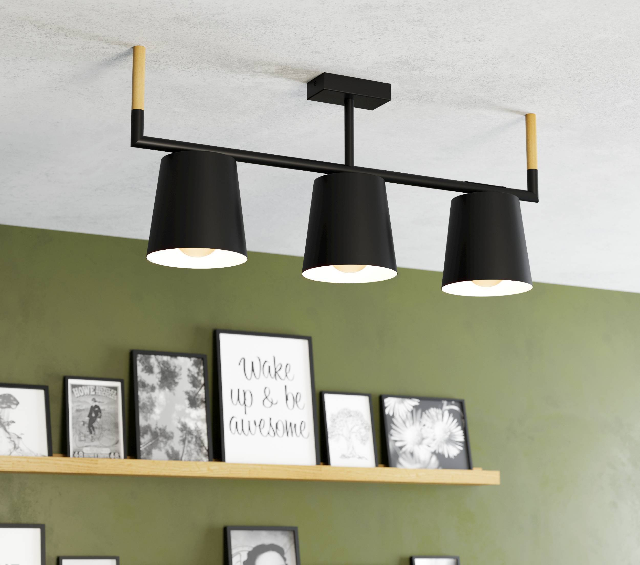 Schwarze Hängelampe mit drei Schirmen, Holzakzenten und Bildern an der Wand darunter.