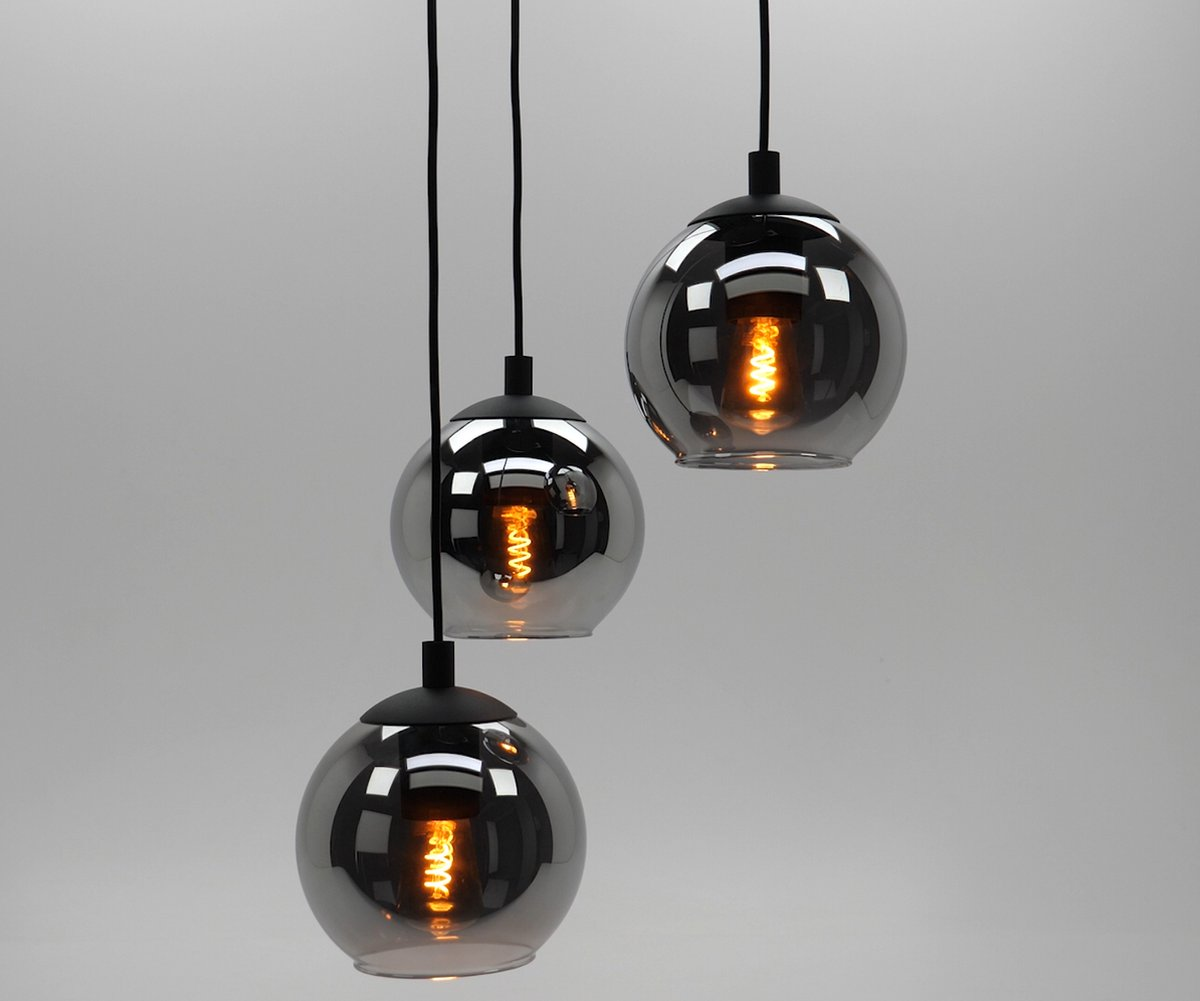 Tre lampade a sospensione con globi in vetro fumé e lampadine calde visibili, su sfondo bianco.