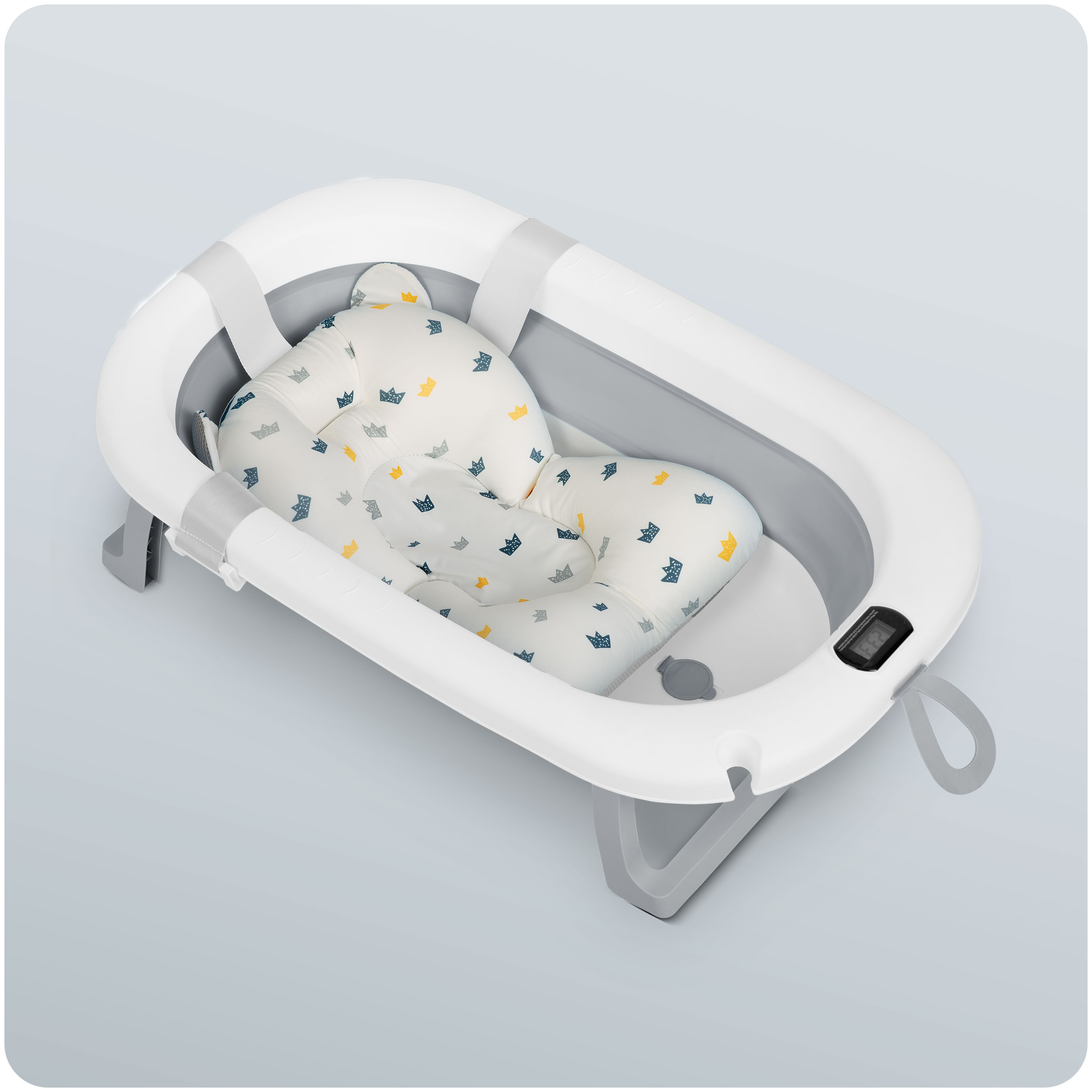 Wanienka dla dziecka w białym i szarym kolorze. Posiada miękką, wyściełaną wkładkę z wzorem korony i cyfrowy wyświetlacz temperatury.