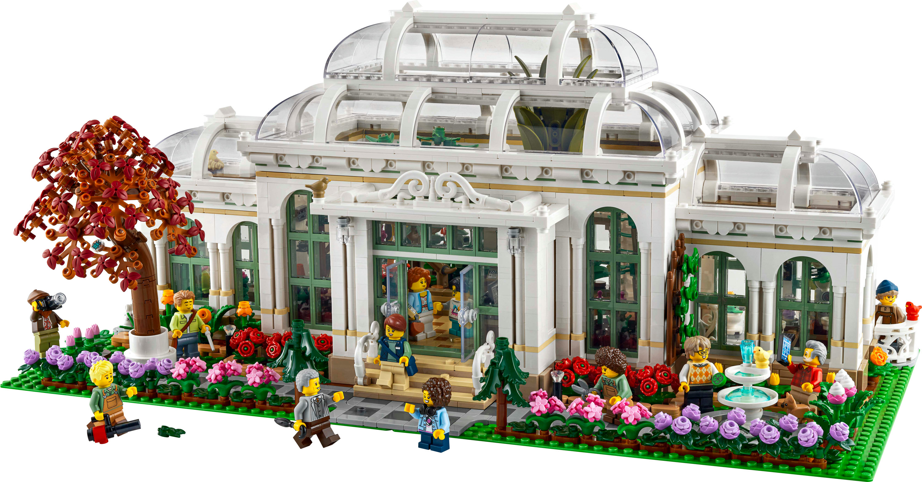 Zestaw Lego Ogród Botaniczny z białym budynkiem, szklanymi oknami i minifigurkami. Czerwone, różowe kwiaty i drzewa.