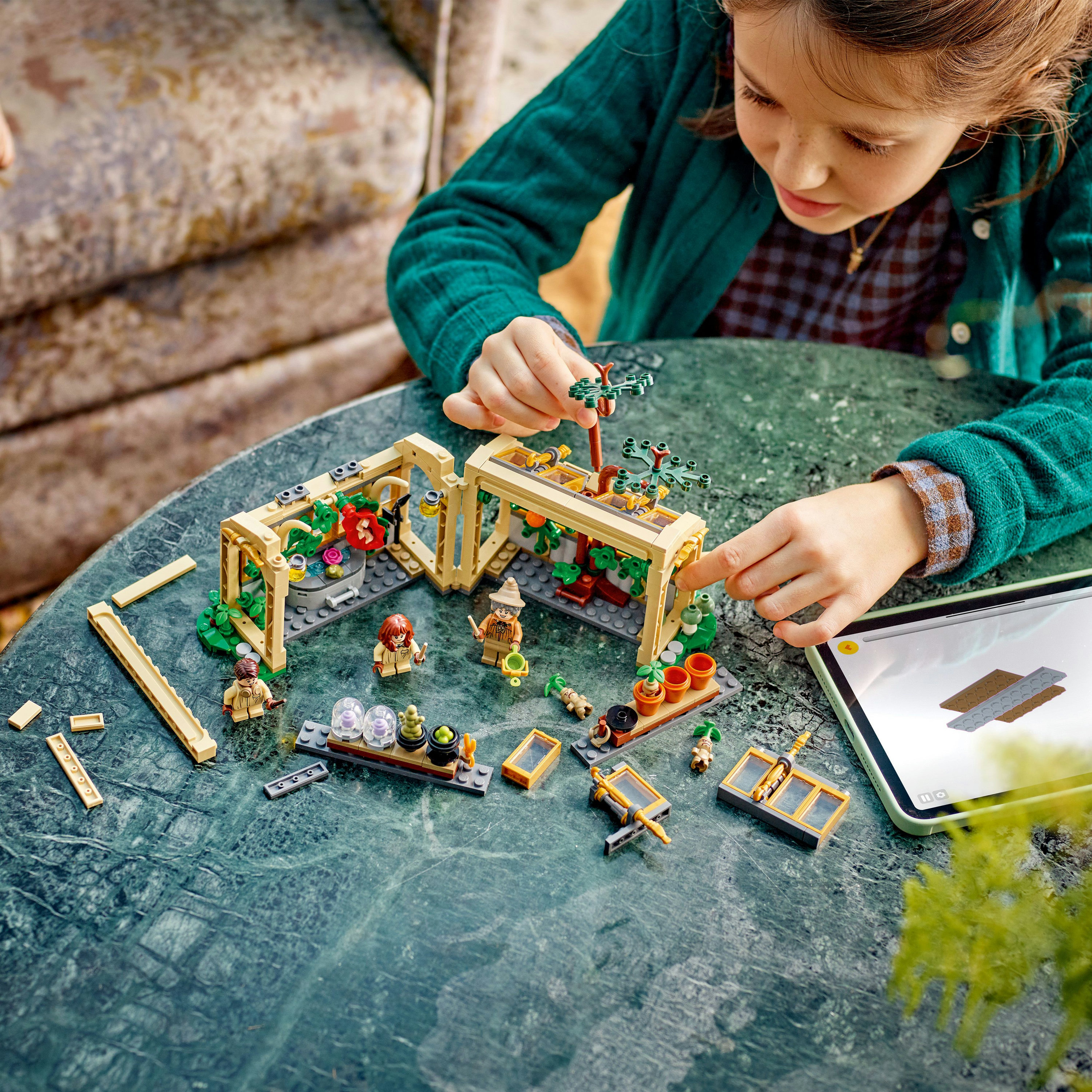 Una niña construyendo un set de Lego con una mini figura. La escena está en una mesa de mármol verde con ladrillos dispersos.