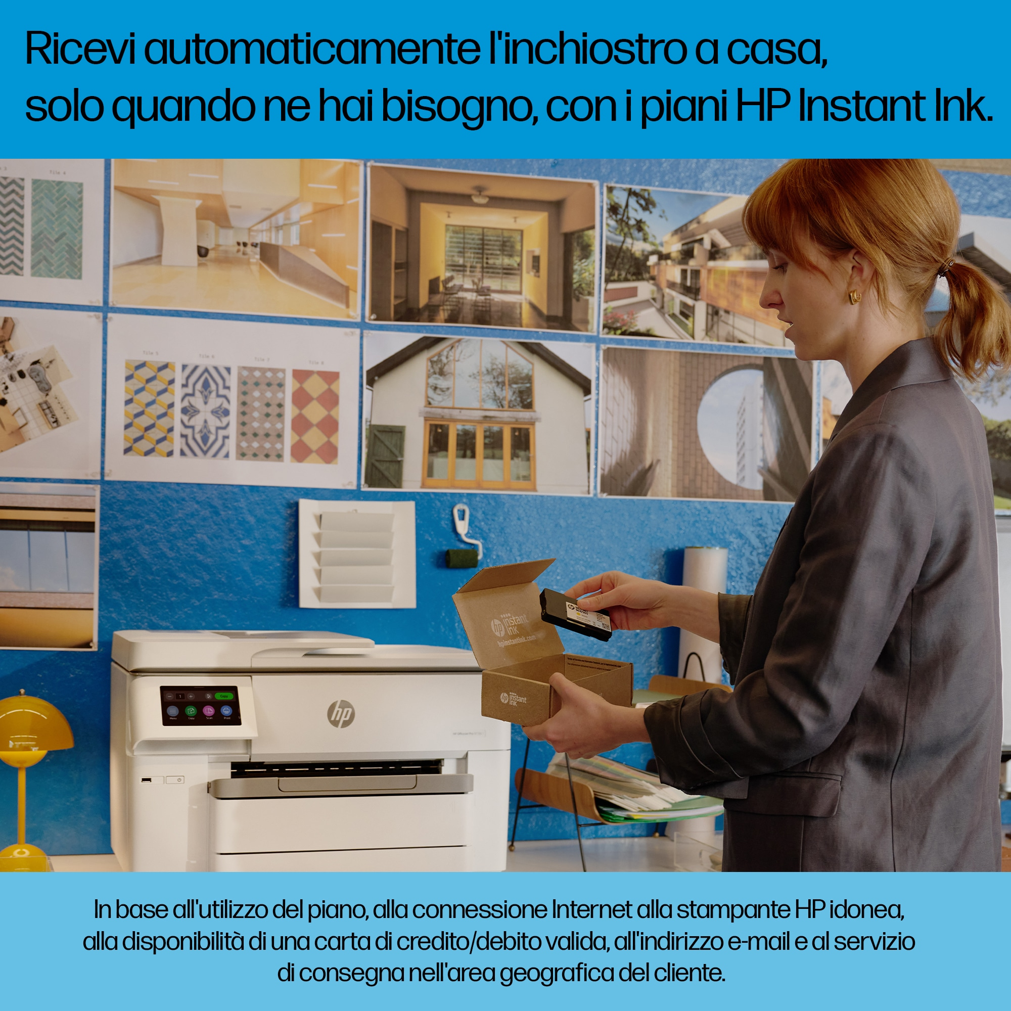Una donna sta aprendo una scatola di inchiostro per stampante, con una stampante sullo sfondo e un muro blu.