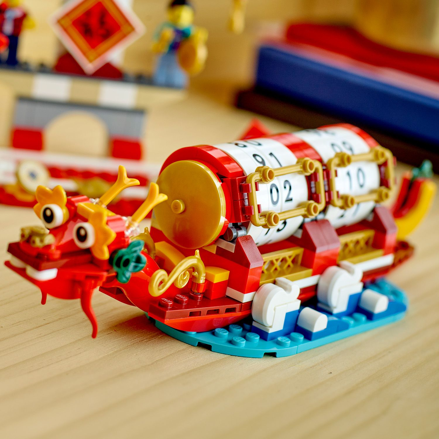 Una barca drago Lego con personaggi ed elementi del calendario. Colori rosso, giallo e blu.