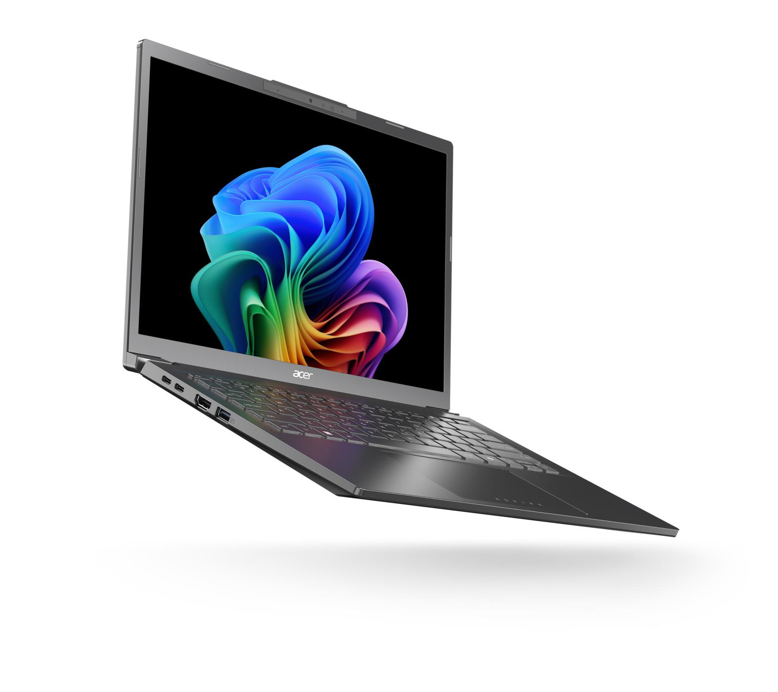 Laptop w powietrzu, widok pod kątem, pokazujący kolorowy wyświetlacz i srebrną obudowę. Białe tło.