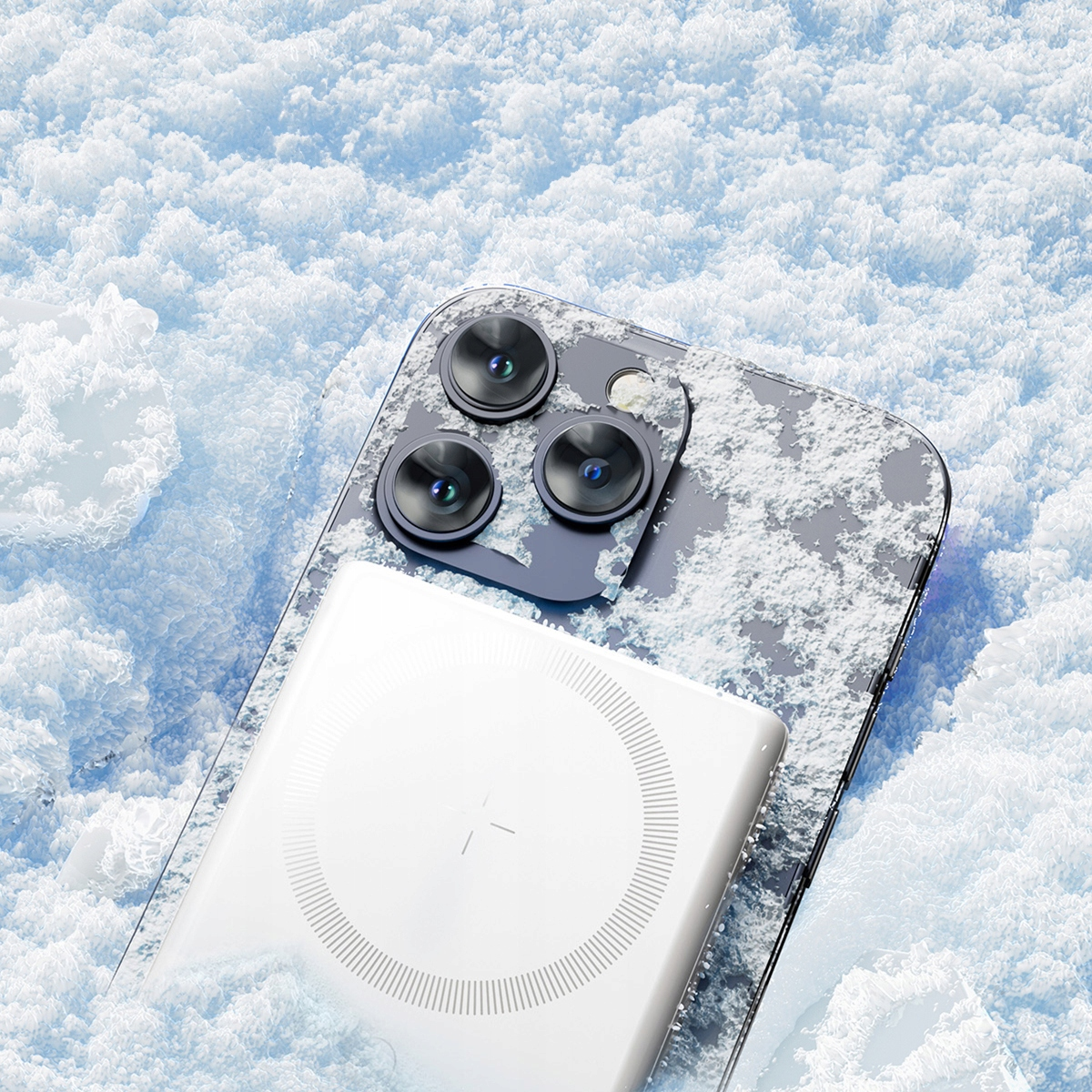 Biały power bank na telefonie w śniegu. Telefon ma trzy aparaty. Bank ma okrągły znak.