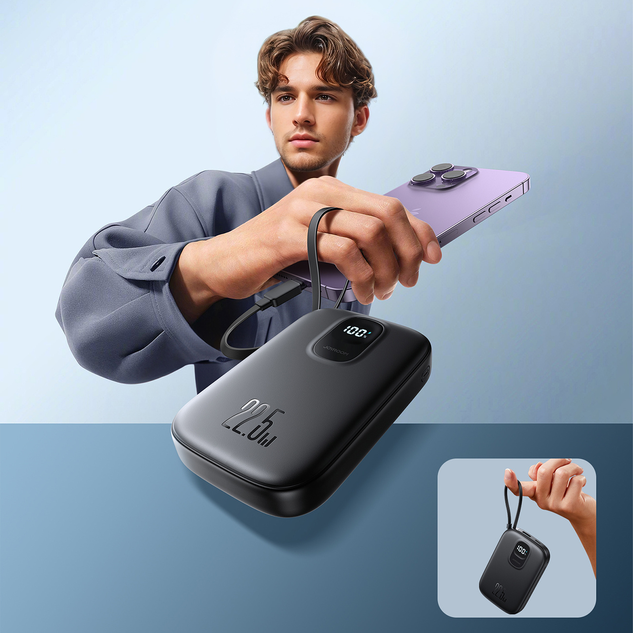 Mężczyzna trzyma czarny power bank, pokazując jego wyświetlacz. Telefon jest w drugiej ręce. Mniejszy obraz jest w rogu.