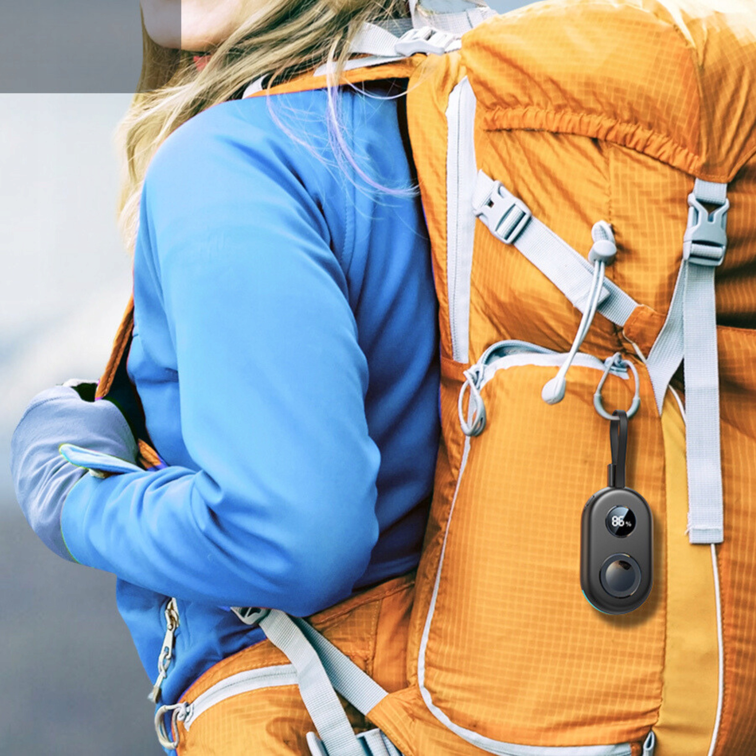 Osoba z plecakiem, z czarnym urządzeniem ładującym zawieszonym na plecaku.