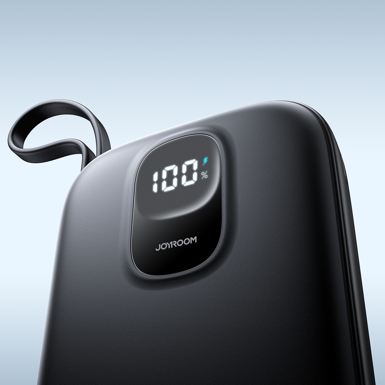 Zbliżenie czarnego power banku. Wyświetlacz pokazuje 100% naładowania.