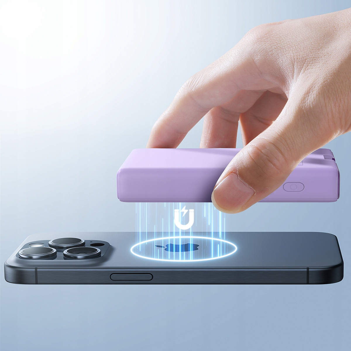Ręka umieszczająca fioletowy power bank na telefonie, aby naładować go bezprzewodowo. Niebieskie linie wskazują ładowanie.