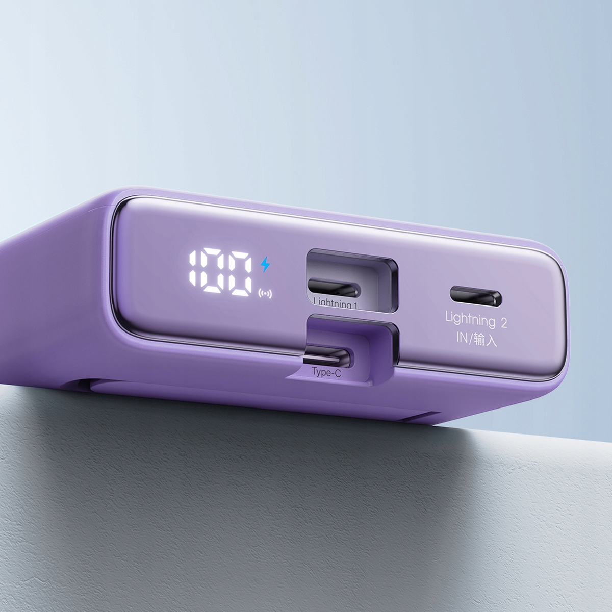 Zbliżenie fioletowego power banku z wyświetlaczem pokazującym 100% i portami ładowania.