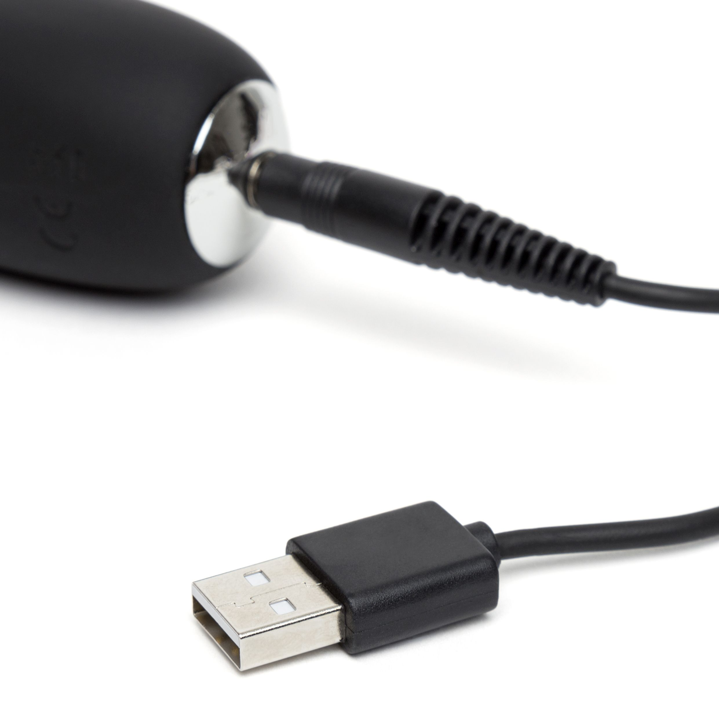 Nahaufnahme eines Sexspielzeugs mit USB-Ladeanschluss, der an ein schwarzes USB-Kabel angeschlossen ist.