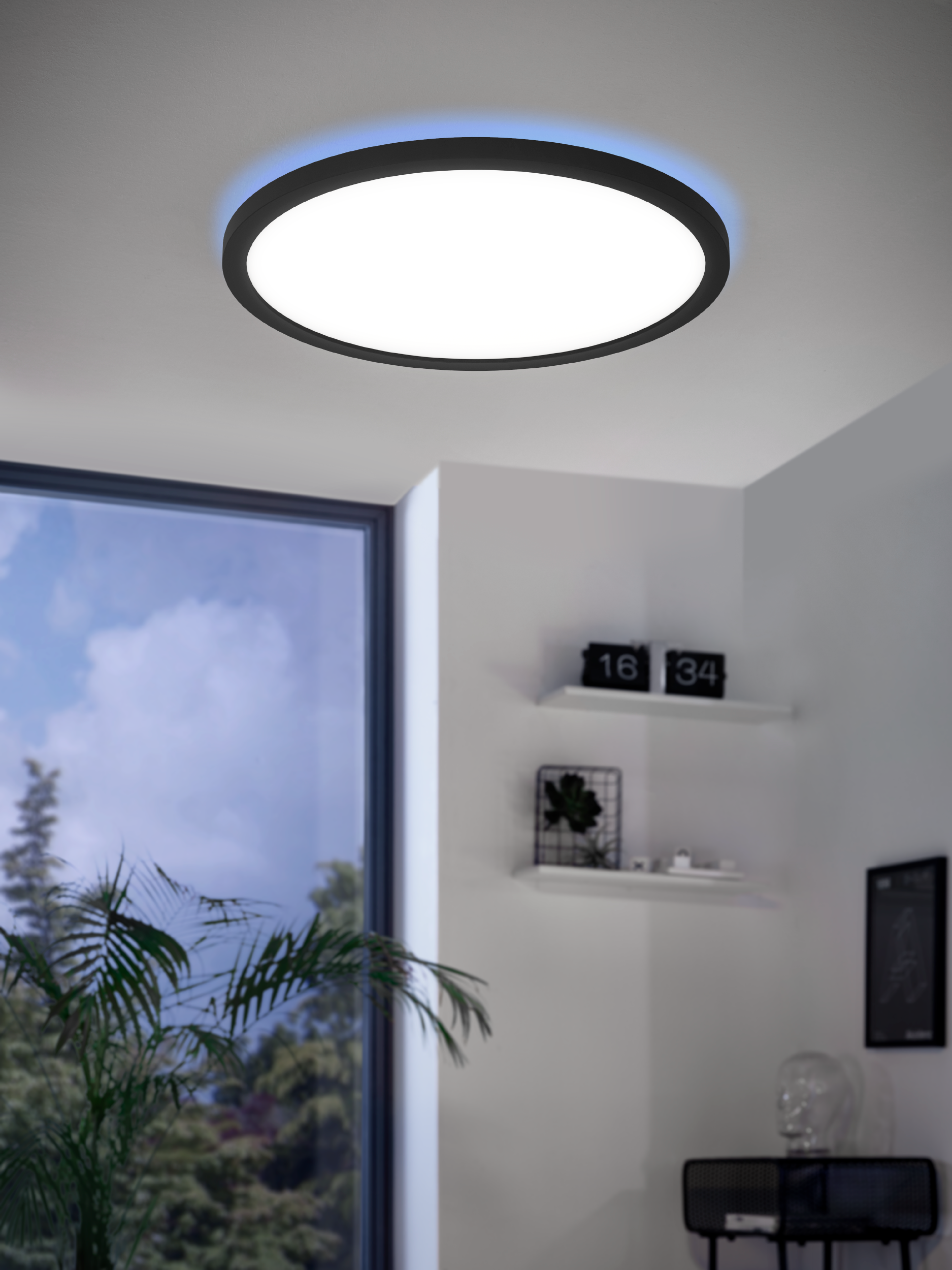 Eine schwarz-weiße LED-Deckenleuchte beleuchtet einen Raum mit Fenster und Dekoration.