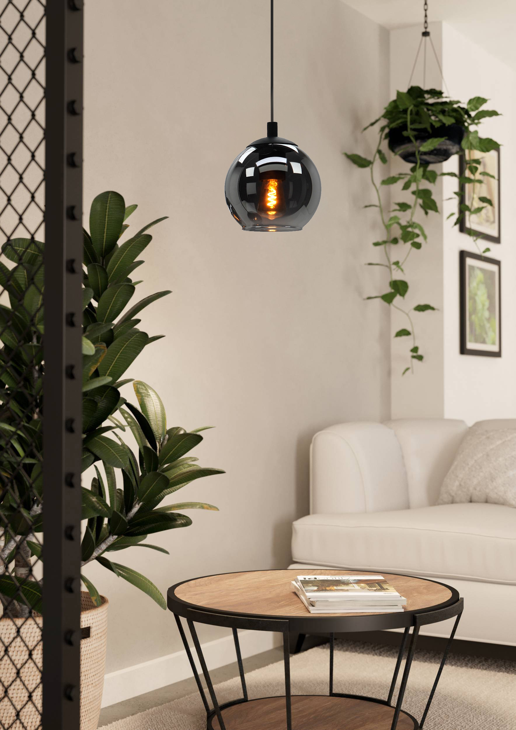 Soggiorno con lampada a sospensione in vetro grigio, piante verdi, divano bianco e un tavolo rotondo.