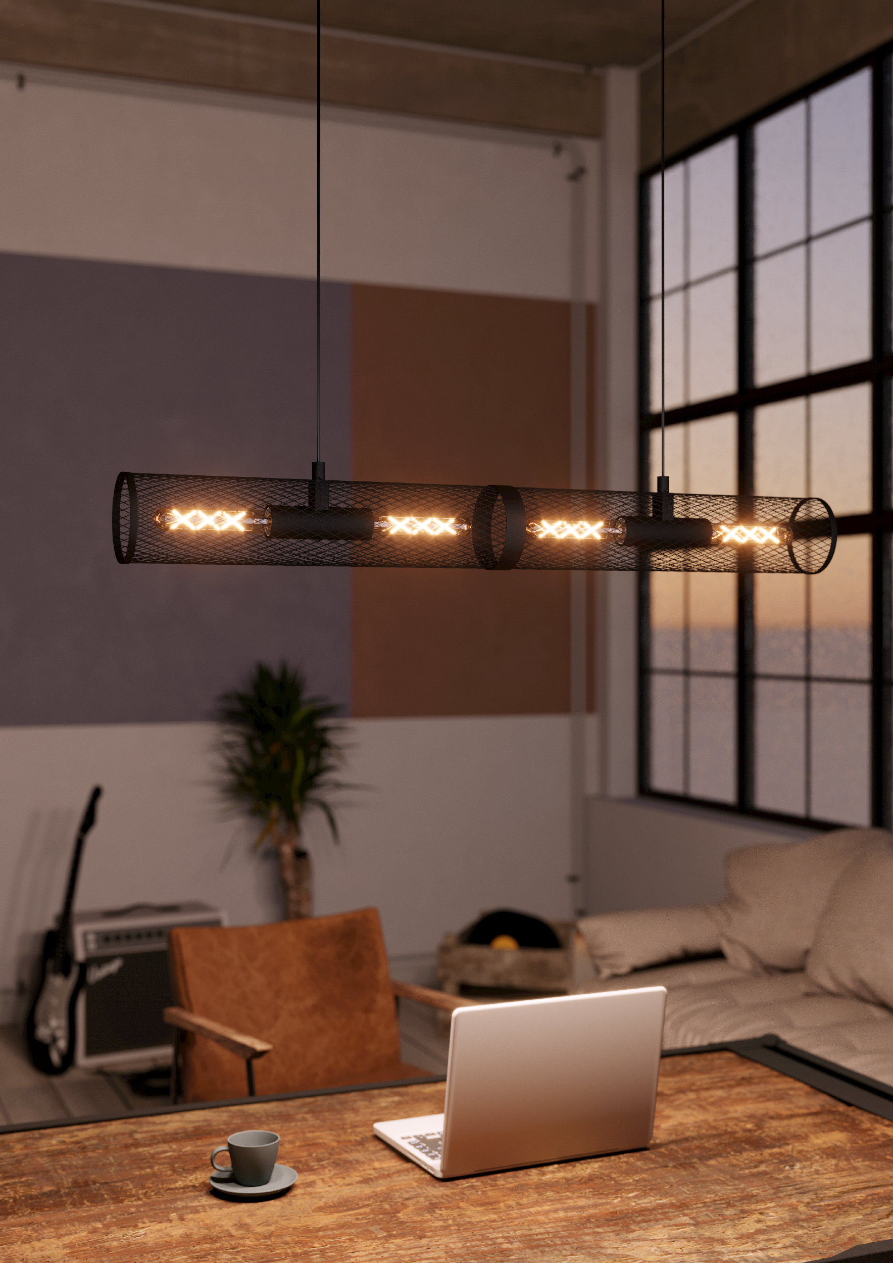 Eine schwarze Metallgitter-Pendelleuchte mit vier Glühbirnen hängt in einem Wohnzimmer.