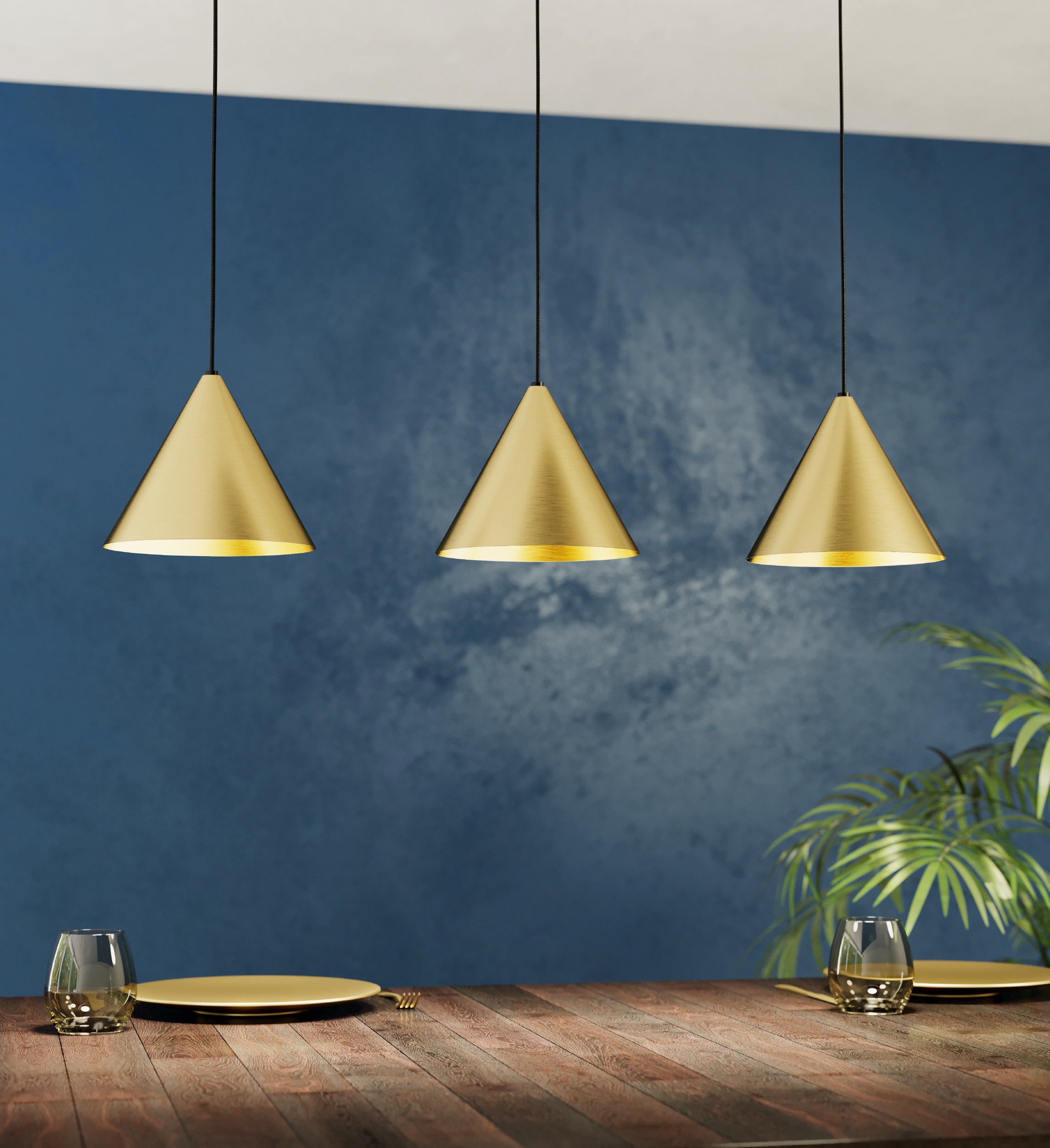 Drei goldene Kegelpendelleuchten hängen über einem Holztisch mit Tellern und Gläsern.