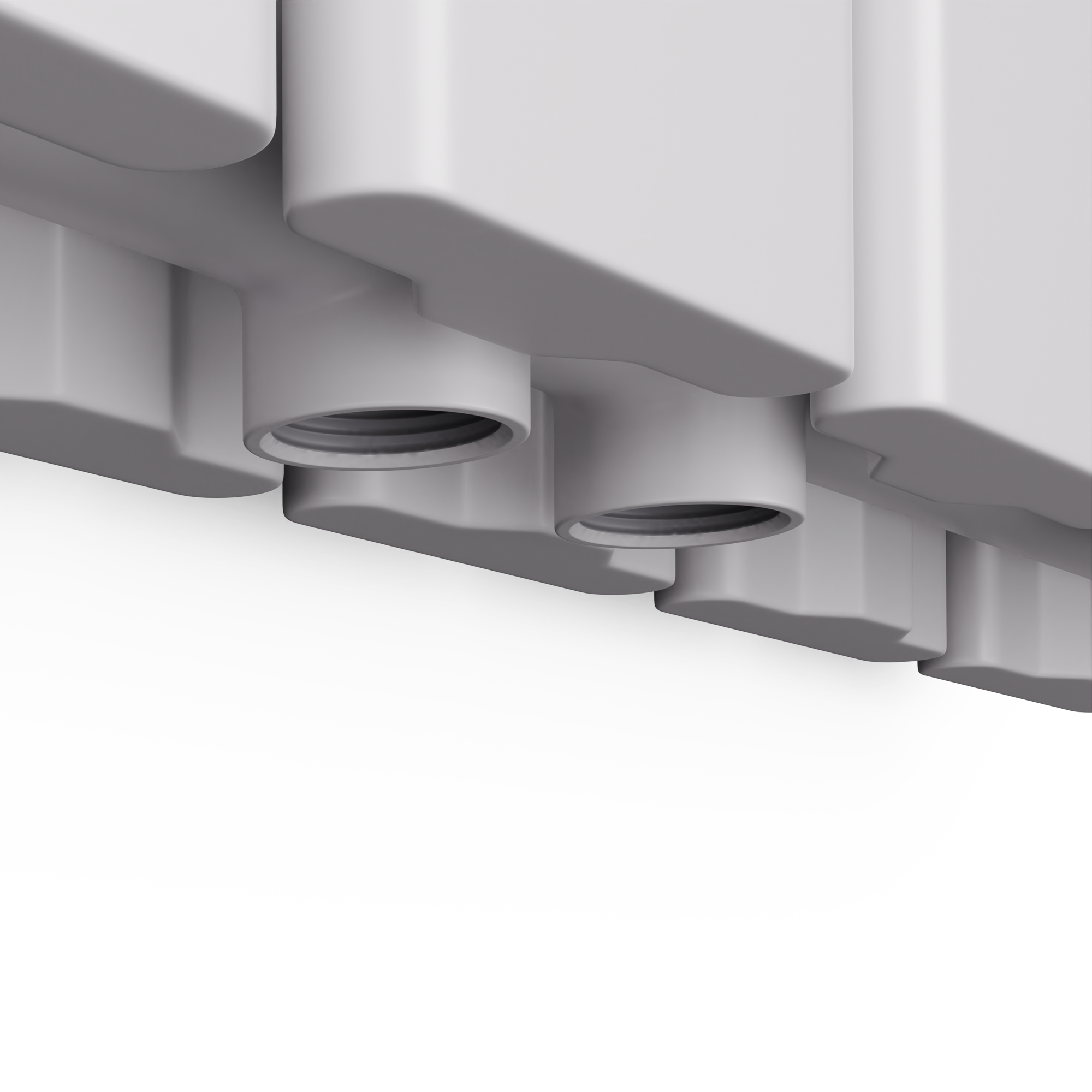 Primo piano della base di un radiatore, che mostra molteplici punti di connessione su sfondo bianco.