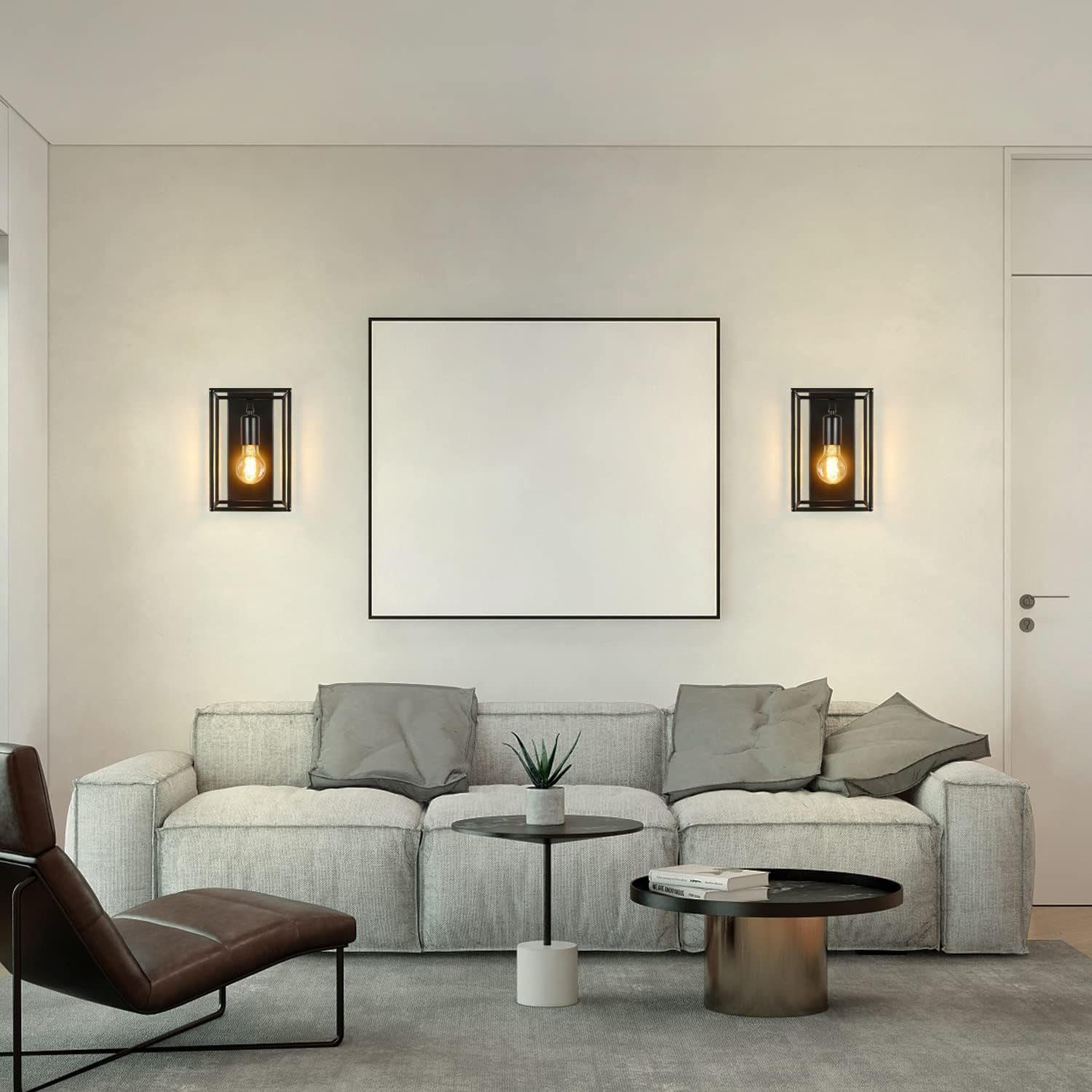 Salon z dwiema czarnymi oprawionymi lampami ściennymi, które flankują pustą ramkę na zdjęcia nad sofą.