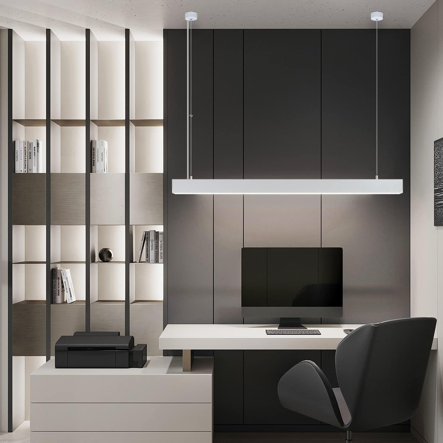 Lampada a sospensione lineare moderna sopra una scrivania con computer e libri.