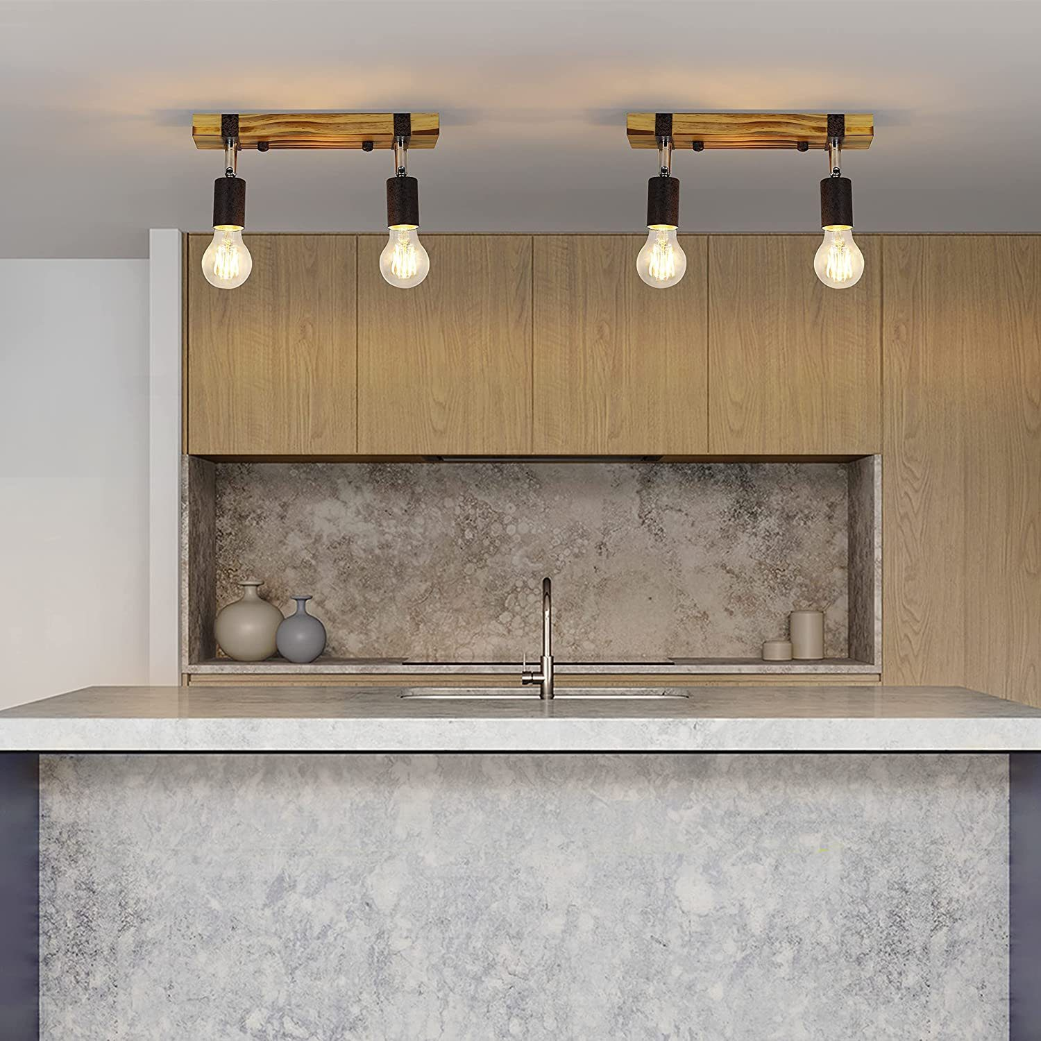 Due lampade in legno pendono sopra un'isola di cucina in una cucina moderna.