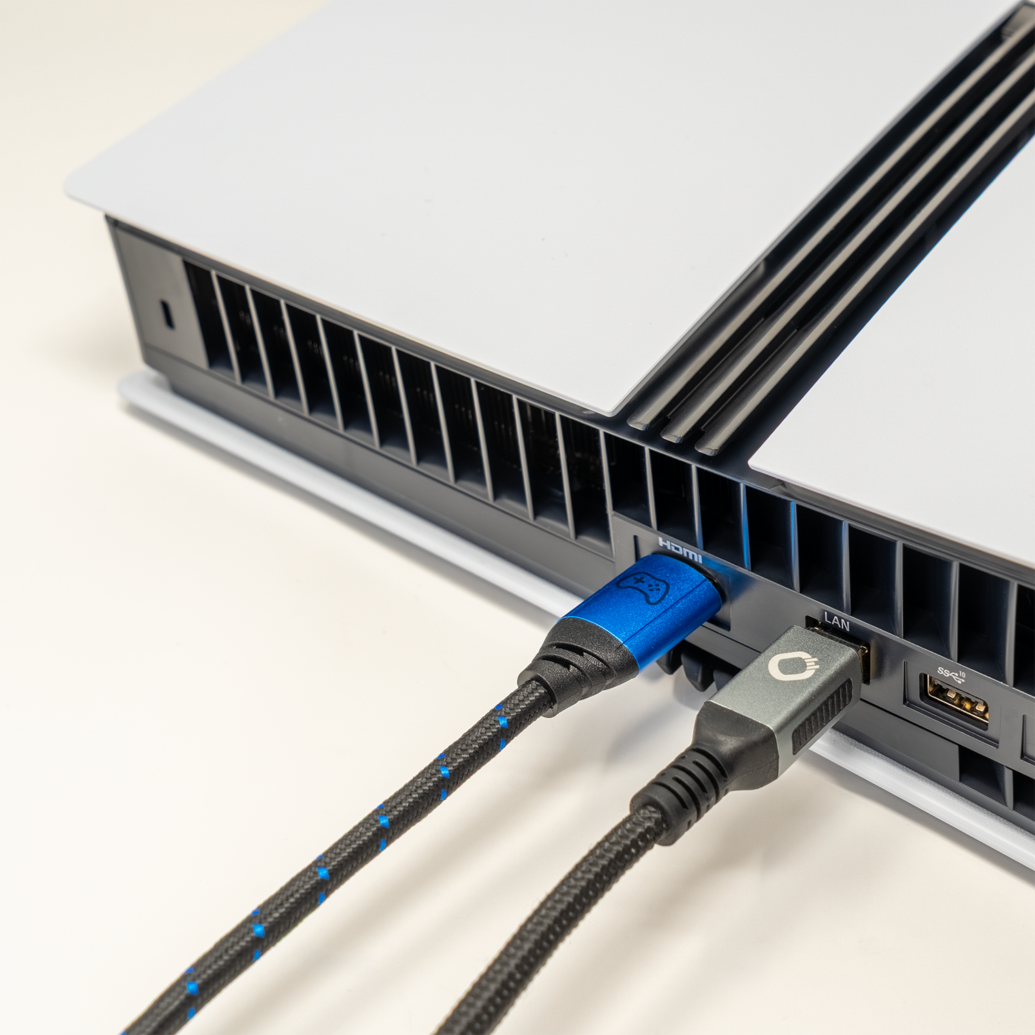 Eine Spielekonsole mit eingesteckten HDMI- und LAN-Kabeln vor einem weißen Hintergrund.