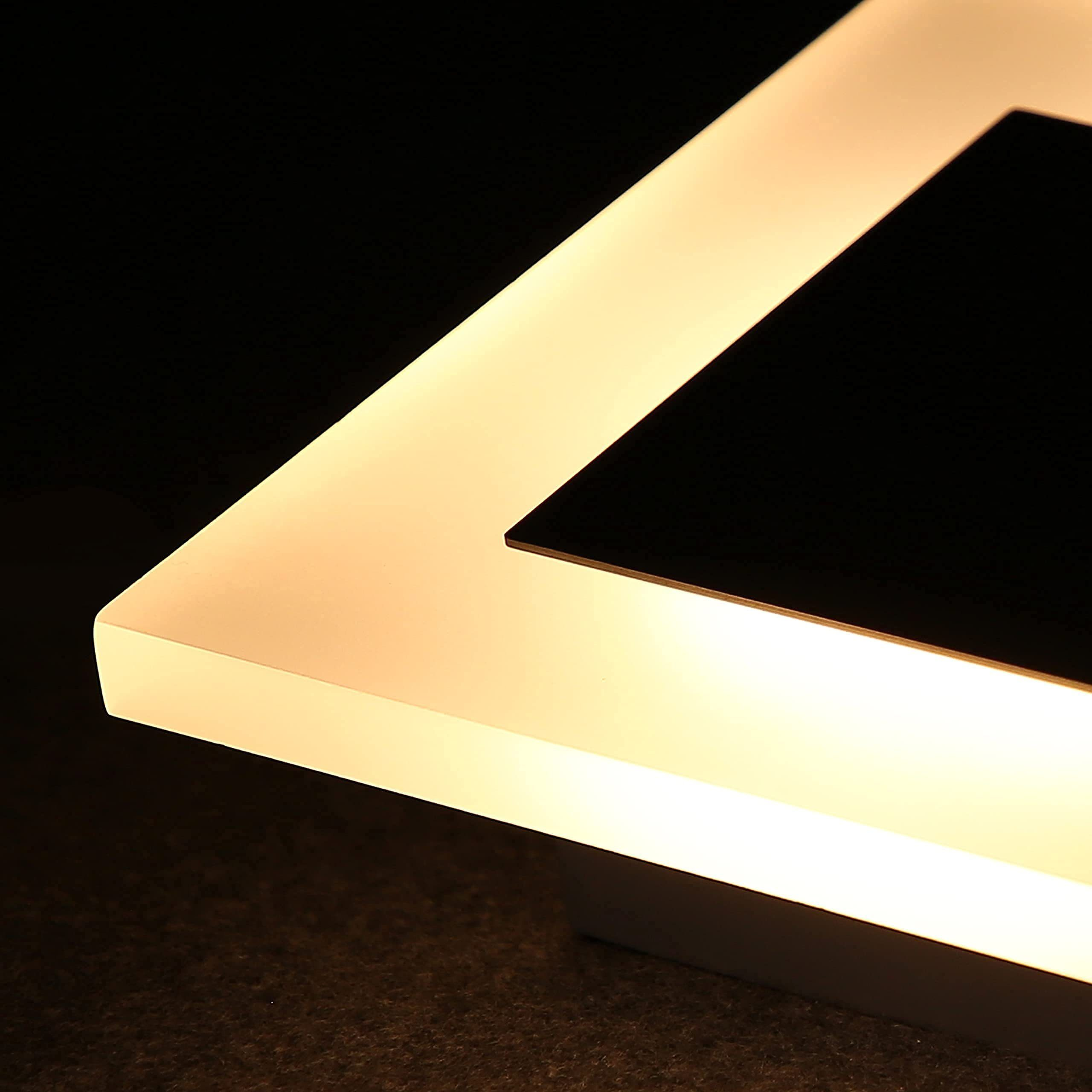 Un primo piano di una lampada LED quadrata con un centro nero su uno sfondo scuro.